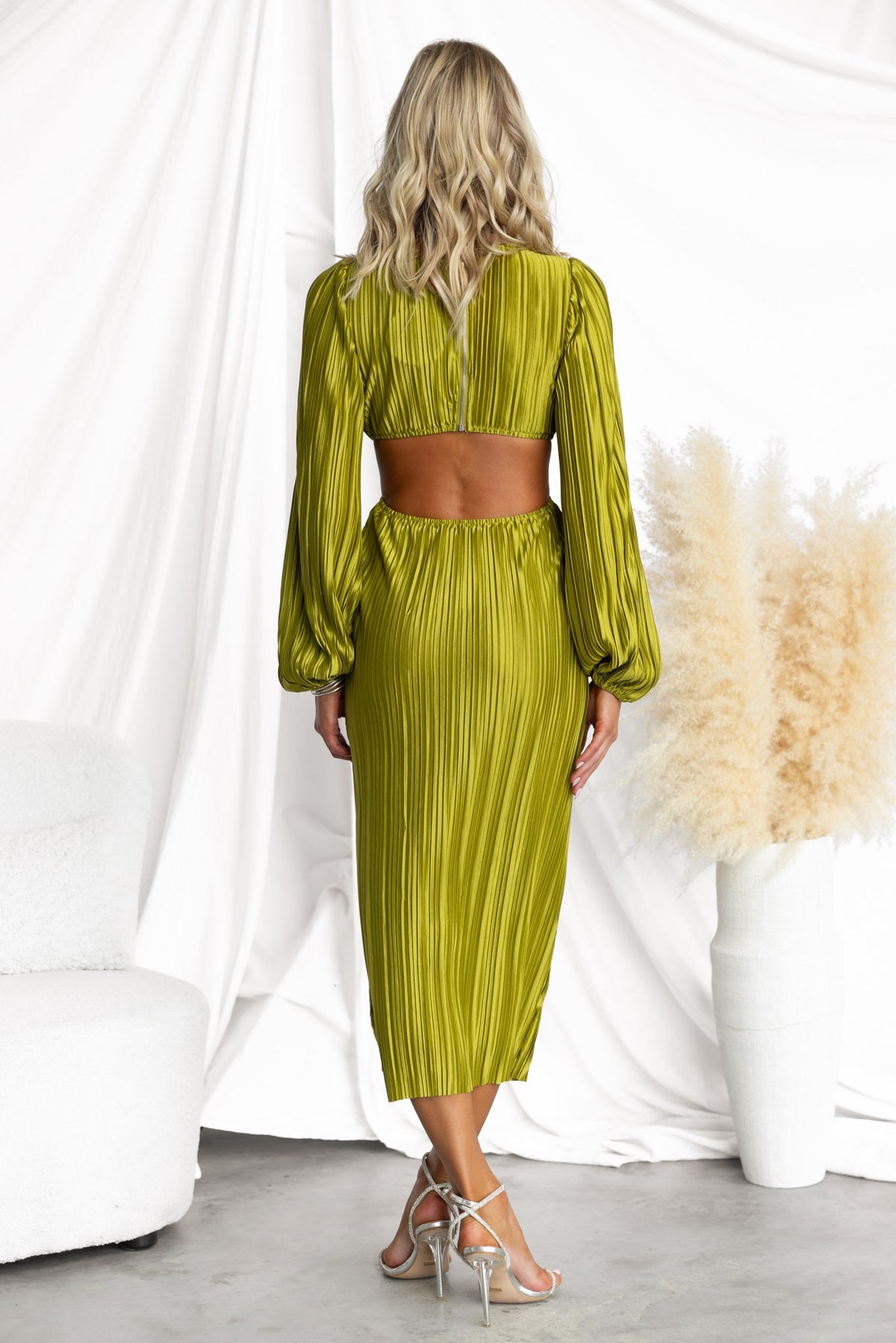 Back view of Aulia Midi Dress in olive green with accordion pleats and puff sleeves, featuring cut-out waist and elegant design.