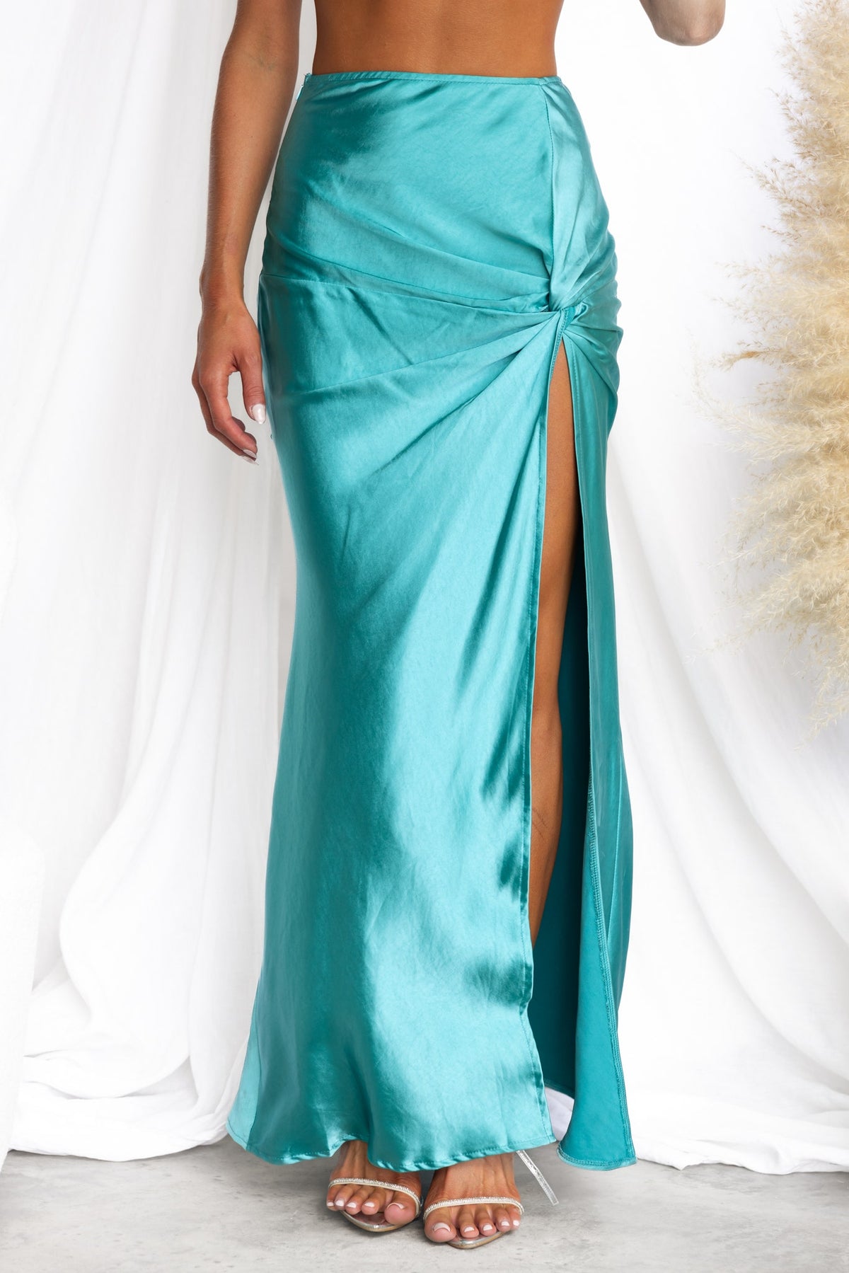 Yasie Maxi Skirt in teal satin with front split and knot detail, showcasing a stylish mid-high waist fit.