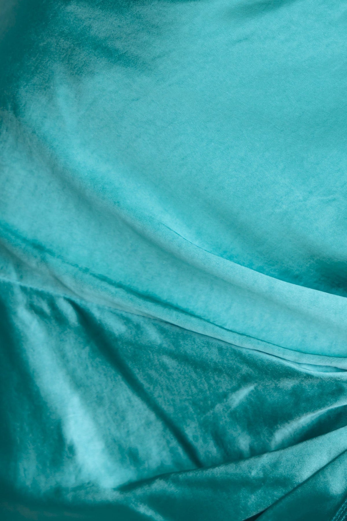 Close-up of the luxurious teal satin fabric of the Yasie Maxi Skirt, showcasing its smooth texture and elegant sheen.