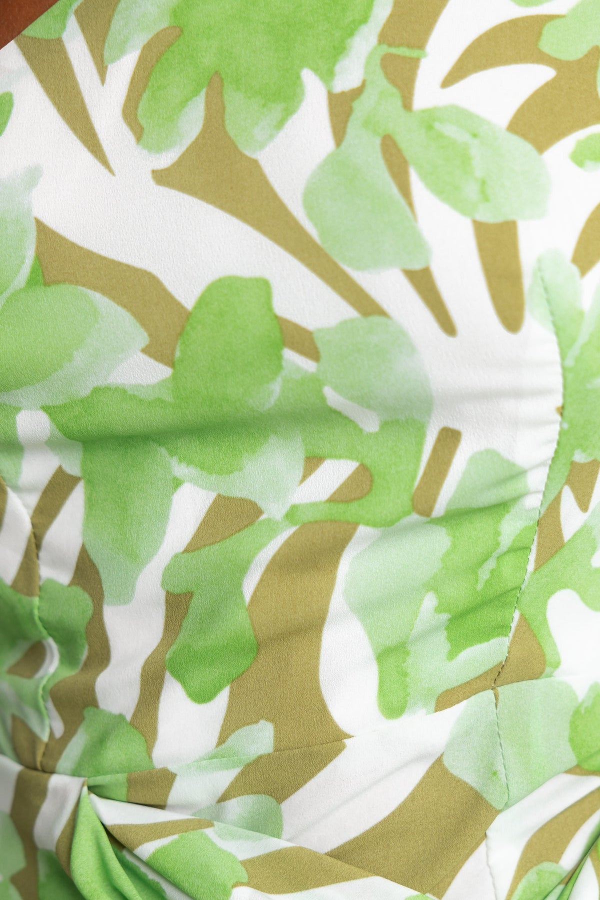 Close-up of floral print fabric in green and beige tones, featured in the Jovanna Midi Dress, highlighting its vibrant design.