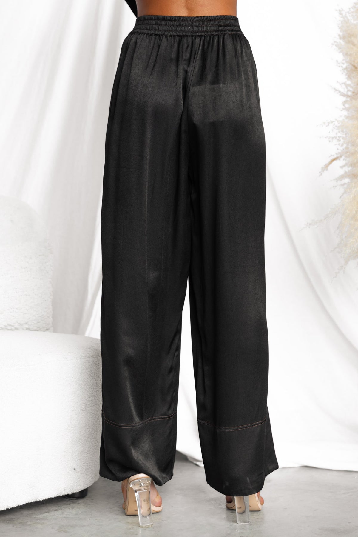 Back view of black Noel Pants with mid-high waist, elastic waistband, and soft silky fabric.