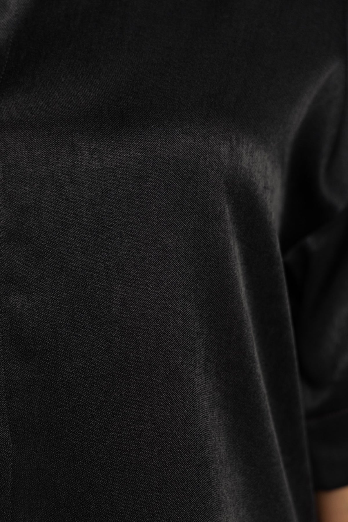 Close-up of soft, silky black fabric showcasing its smooth texture and sheen.