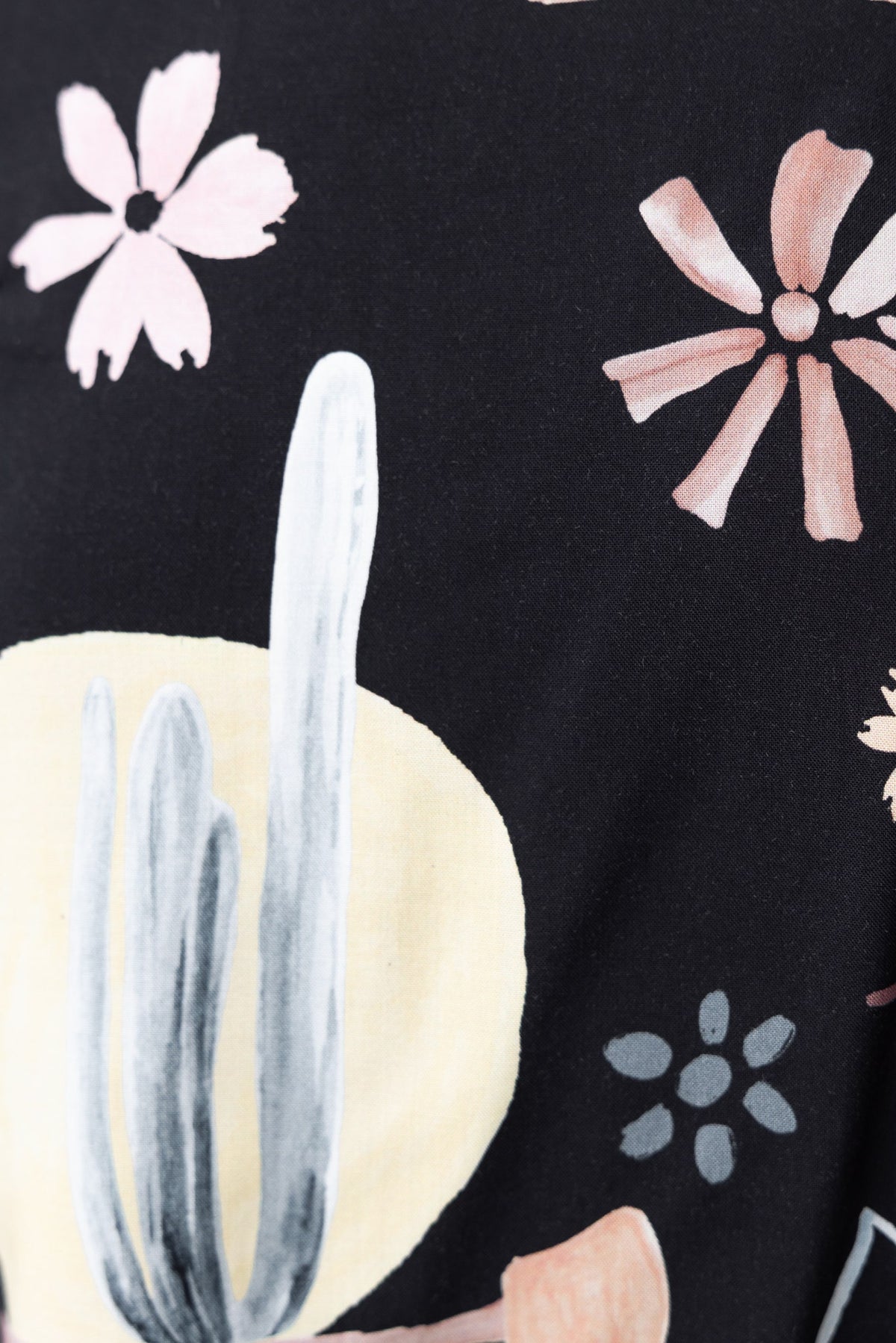 Close-up of black fabric featuring a floral and cactus print design for Frances Shorts.