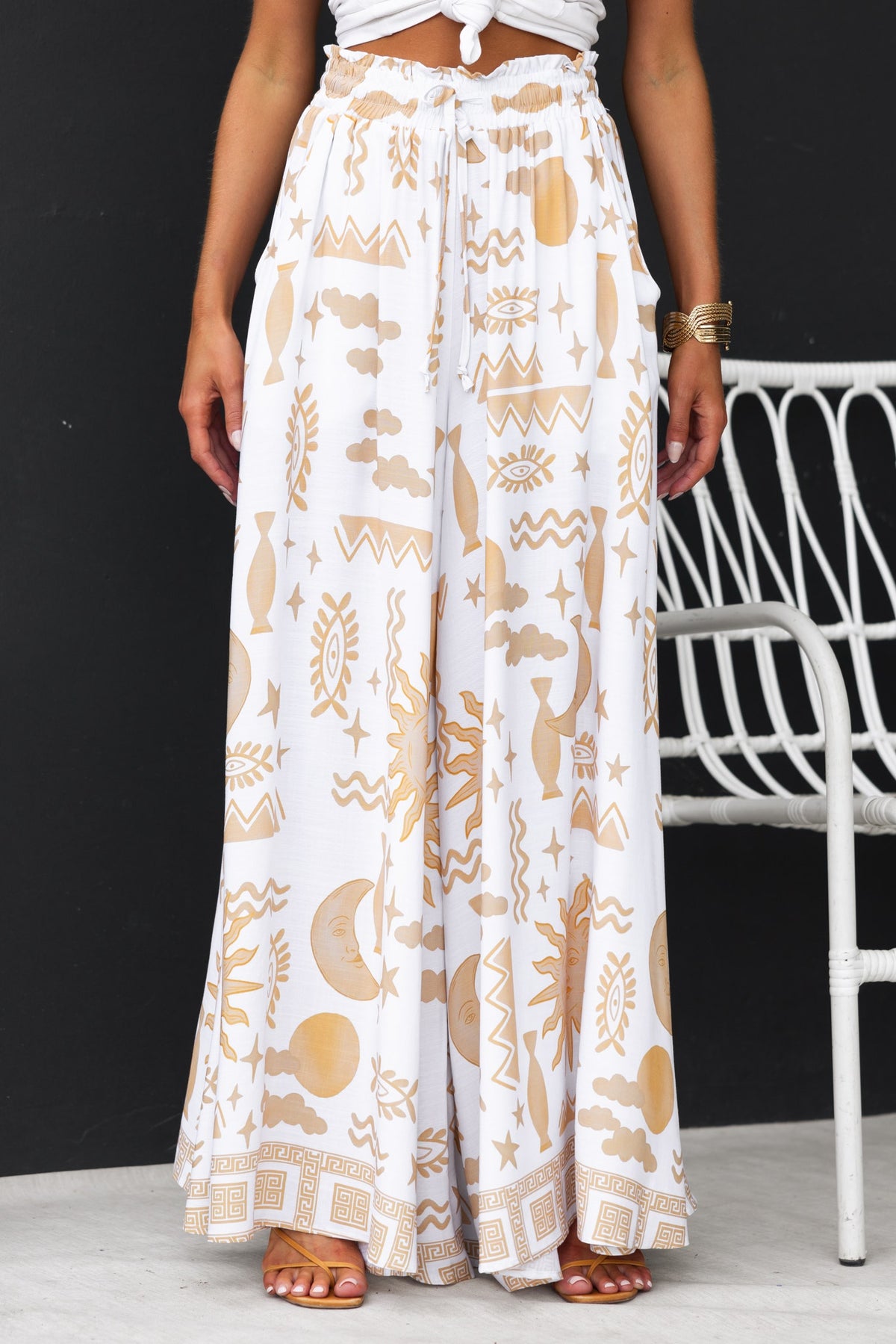 Amadi Pants with abstract print, mid-high waist, elastic waistband, and wide legs in a stylish summer outfit.