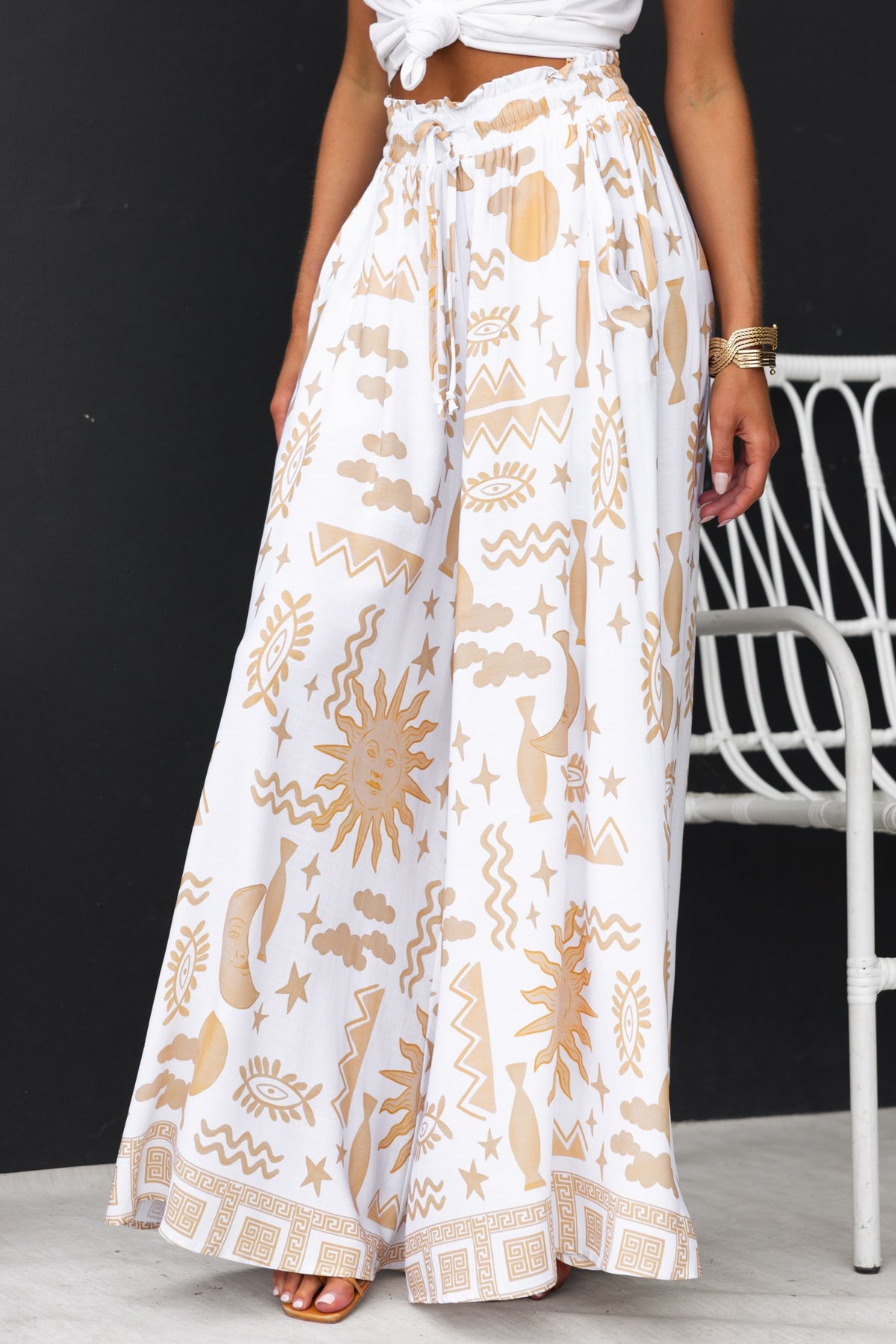 Amadi Pants featuring an abstract print, mid-high waist, elastic drawstring, and wide legs in a light cotton feel.