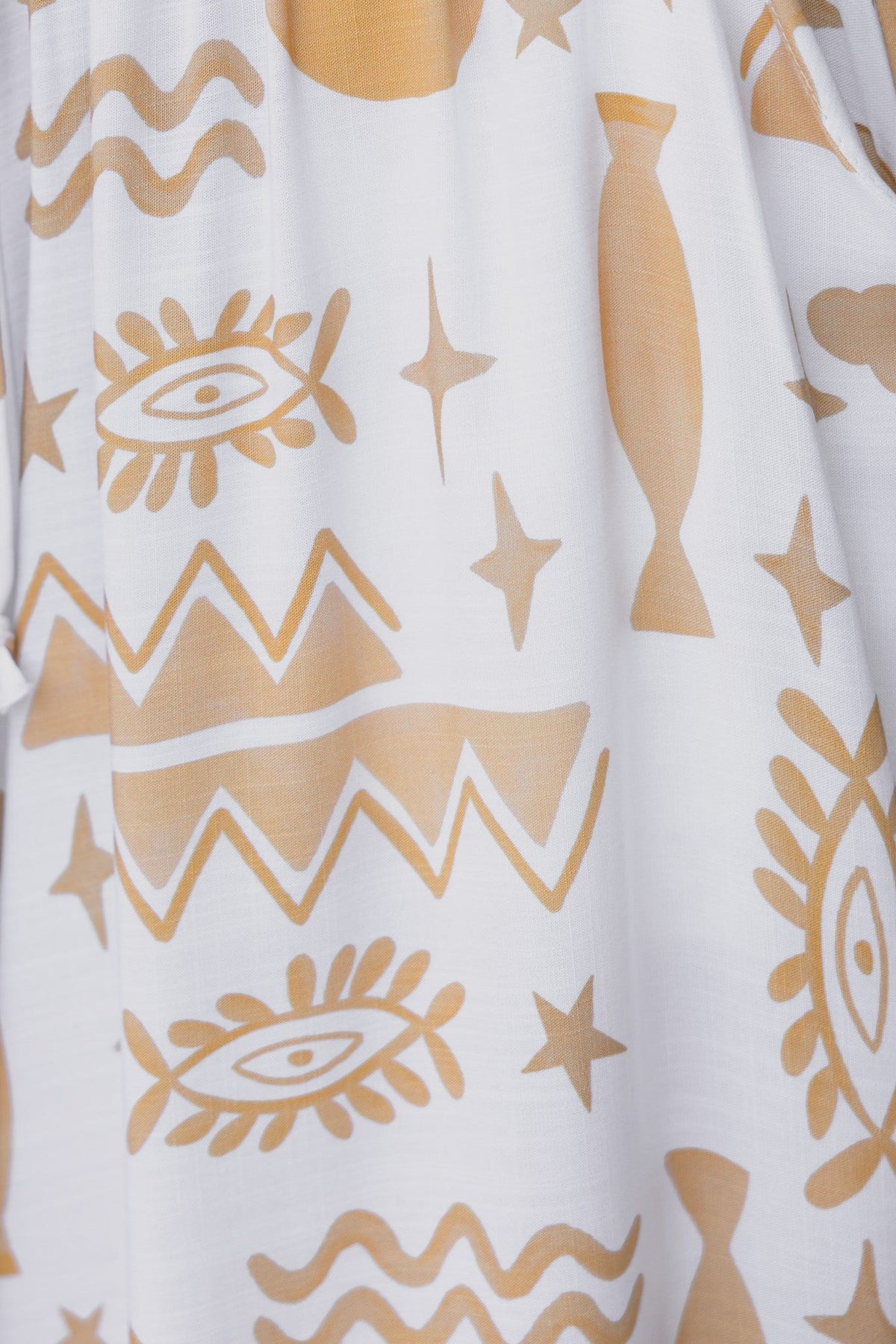 Abstract gold pattern on white fabric, featuring fish, eyes, and geometric shapes, ideal for artistic clothing.