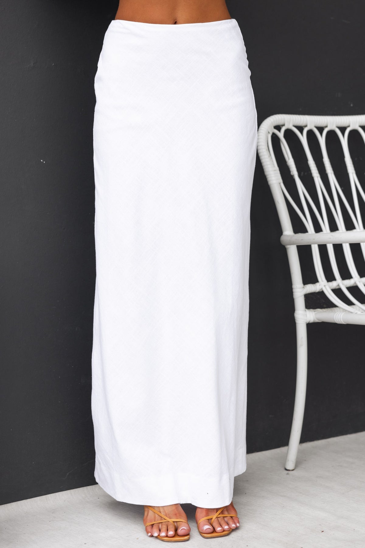 Bexley Maxi Skirt in white, featuring a mid-high waist fit and invisible zip, styled with sandals.