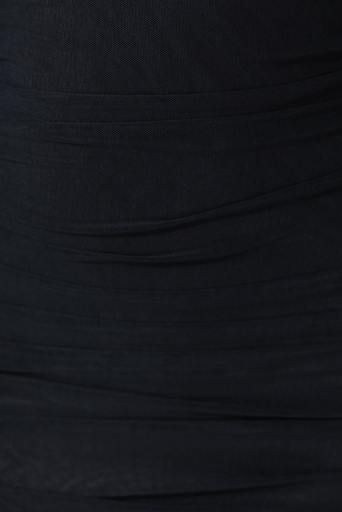 Close-up of the textured fabric of the Saira black bodycon dress featuring ruching details.