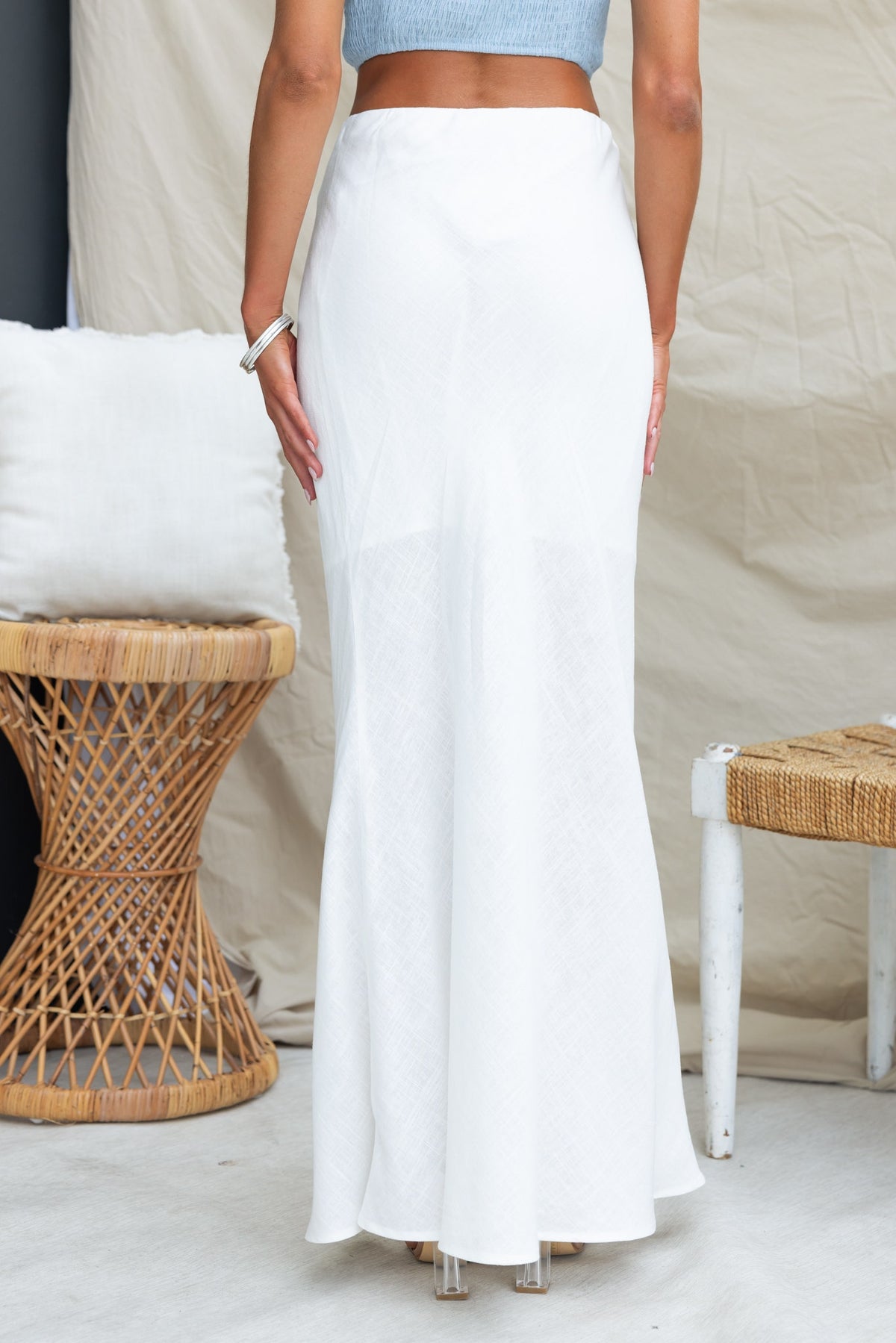 Back view of a white Solani maxi skirt with a mid-high waist and lined to mid-thigh, styled for a casual look.