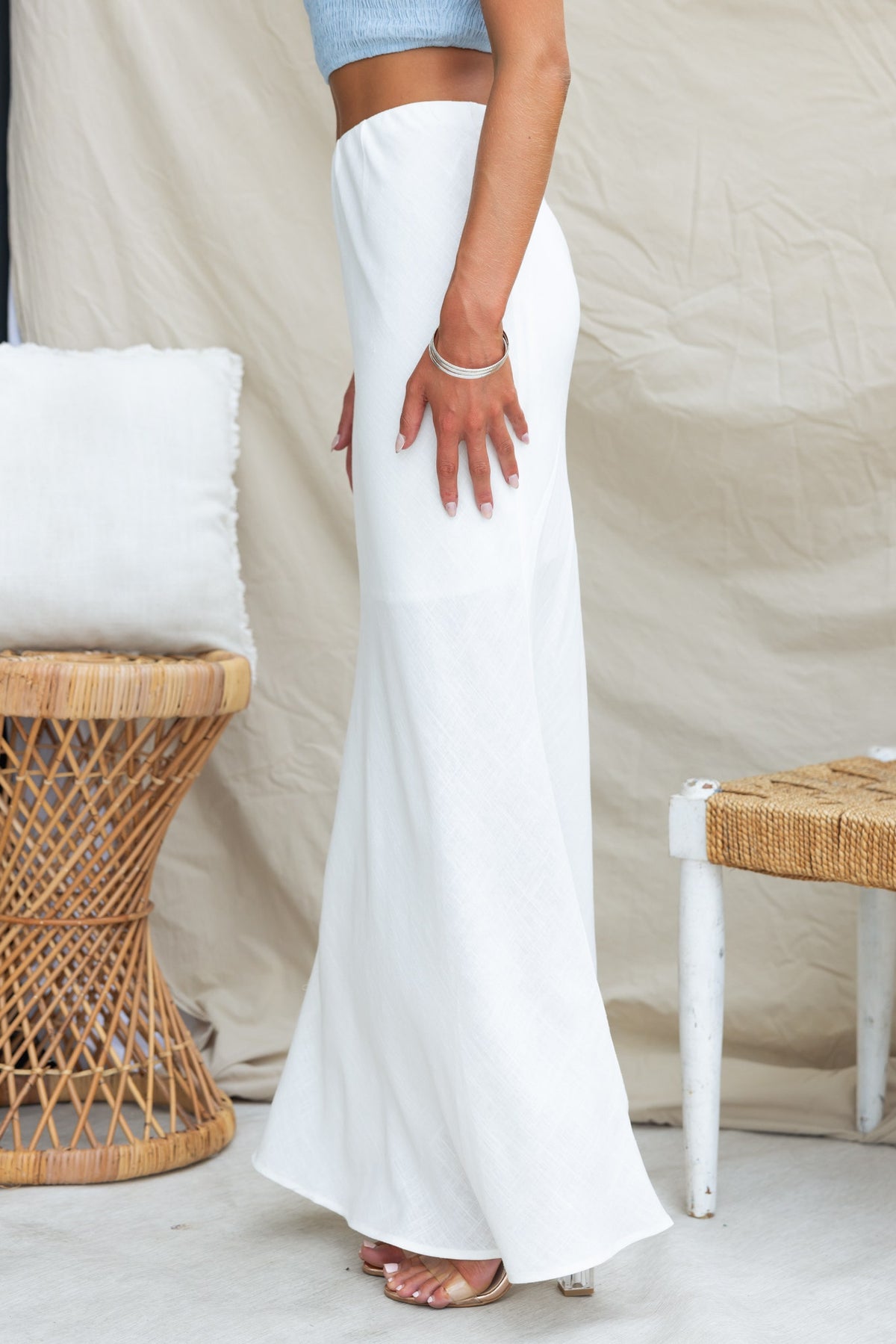 Model wearing Solani Maxi Skirt in white, showcasing mid-high waist and flowy design against neutral backdrop.