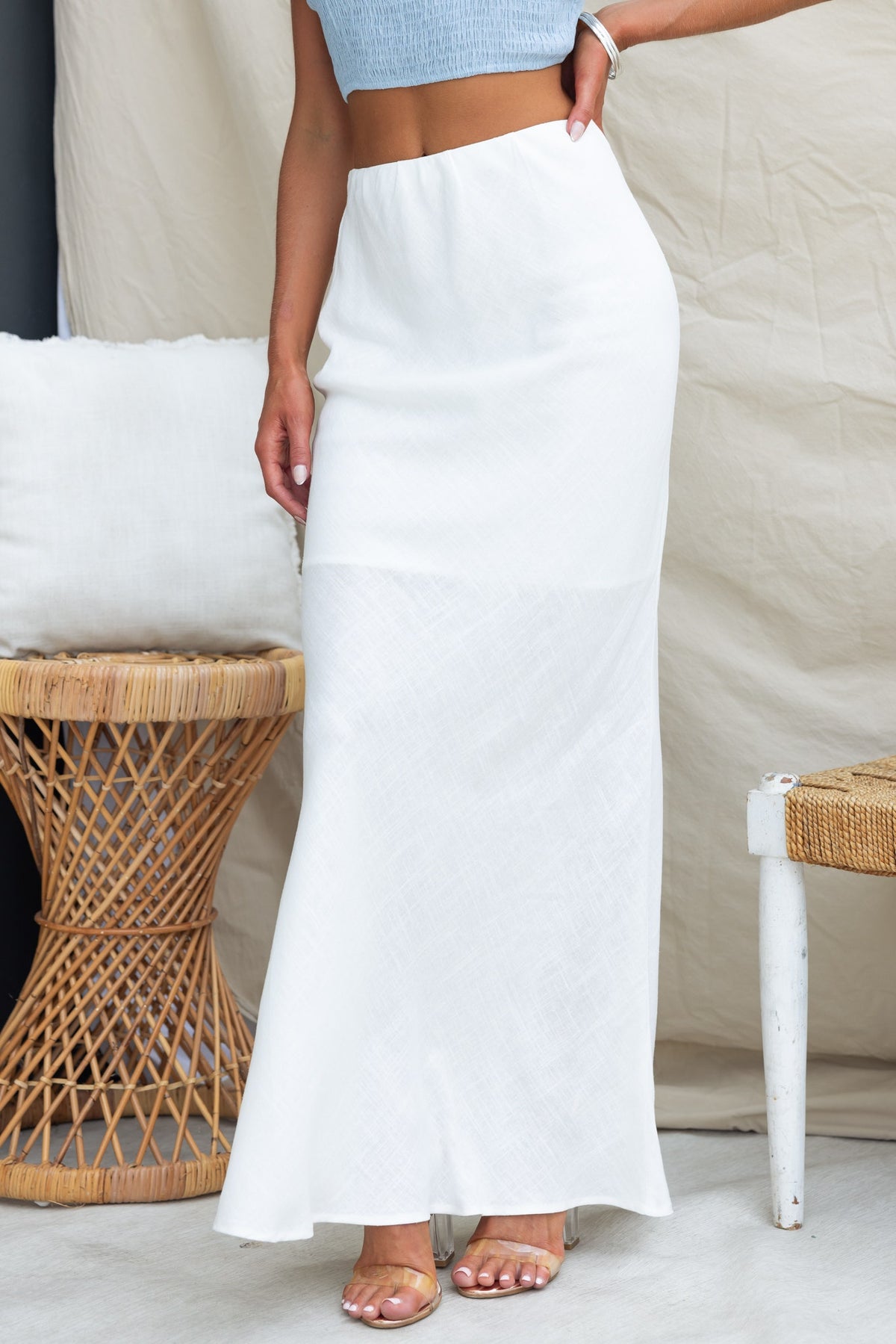 Model wearing the Solani Maxi Skirt, featuring a mid-high waist, elastic waistband, and a flowing white design.