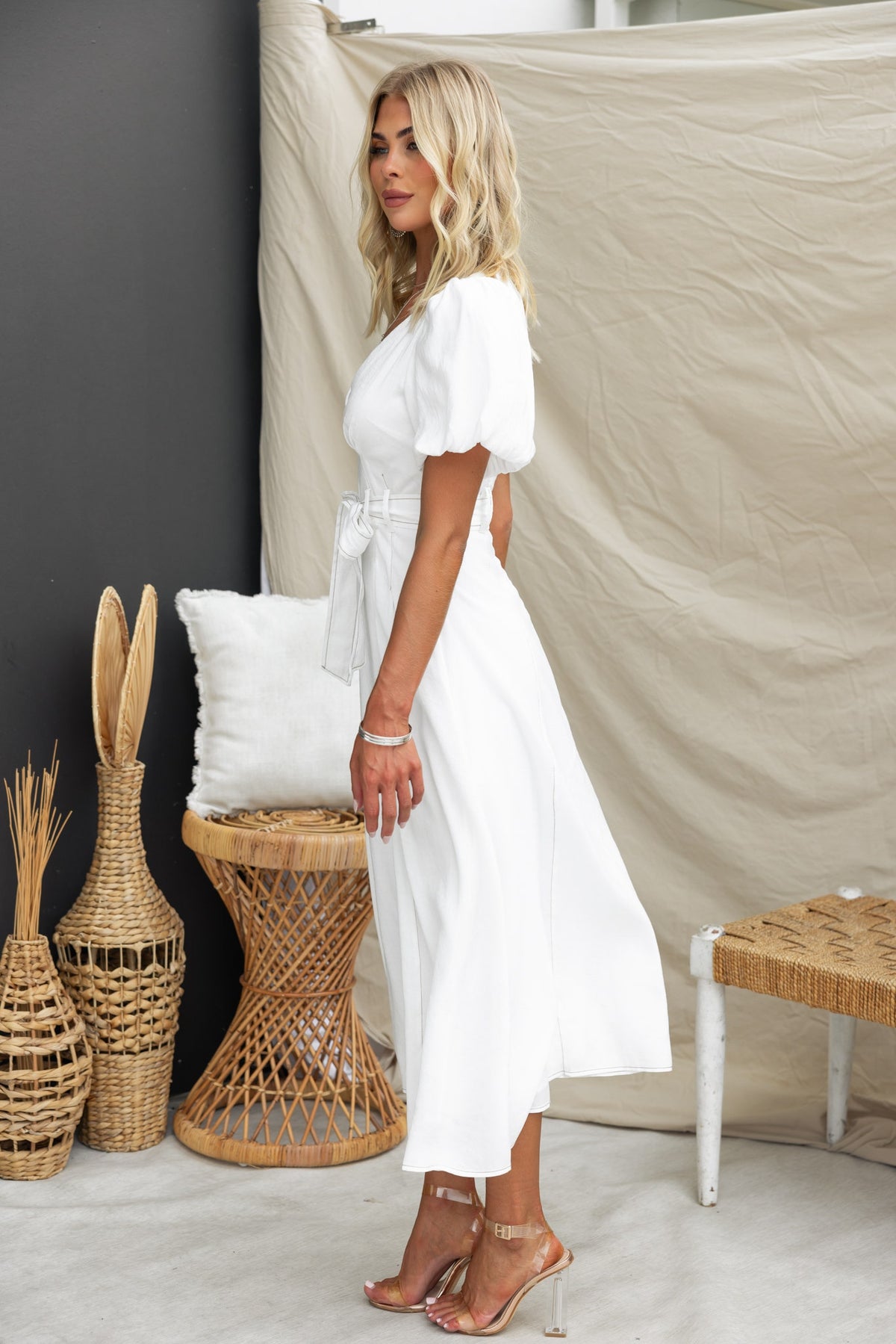 Orderly Midi Dress in white, featuring a V-neckline, puff sleeves, and removable fabric tie, styled with elegant sandals.