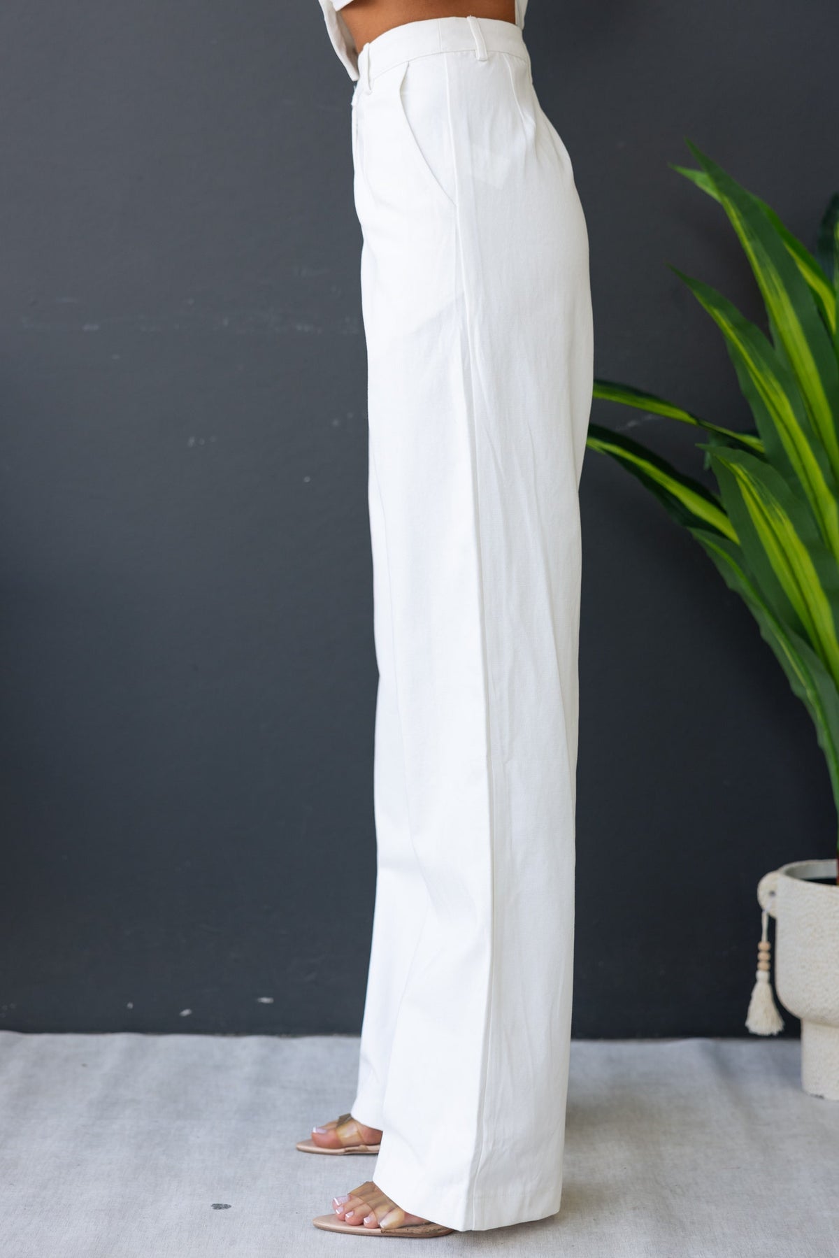 Side view of Rayden Denim Pants in white, featuring a mid-high waist fit and wide legs, styled with a modern aesthetic.