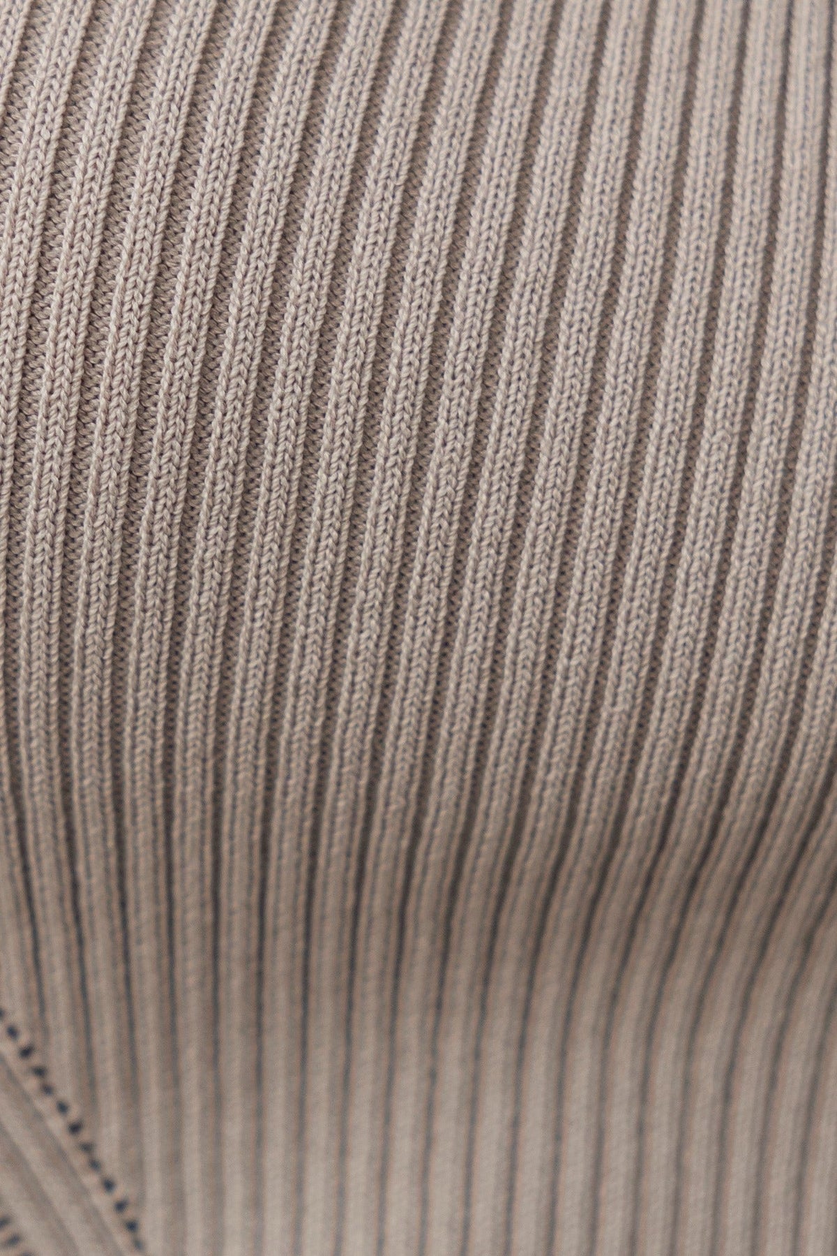 Close-up of ribbed knit fabric in beige color, showcasing stretch and texture, perfect for stylish tops.