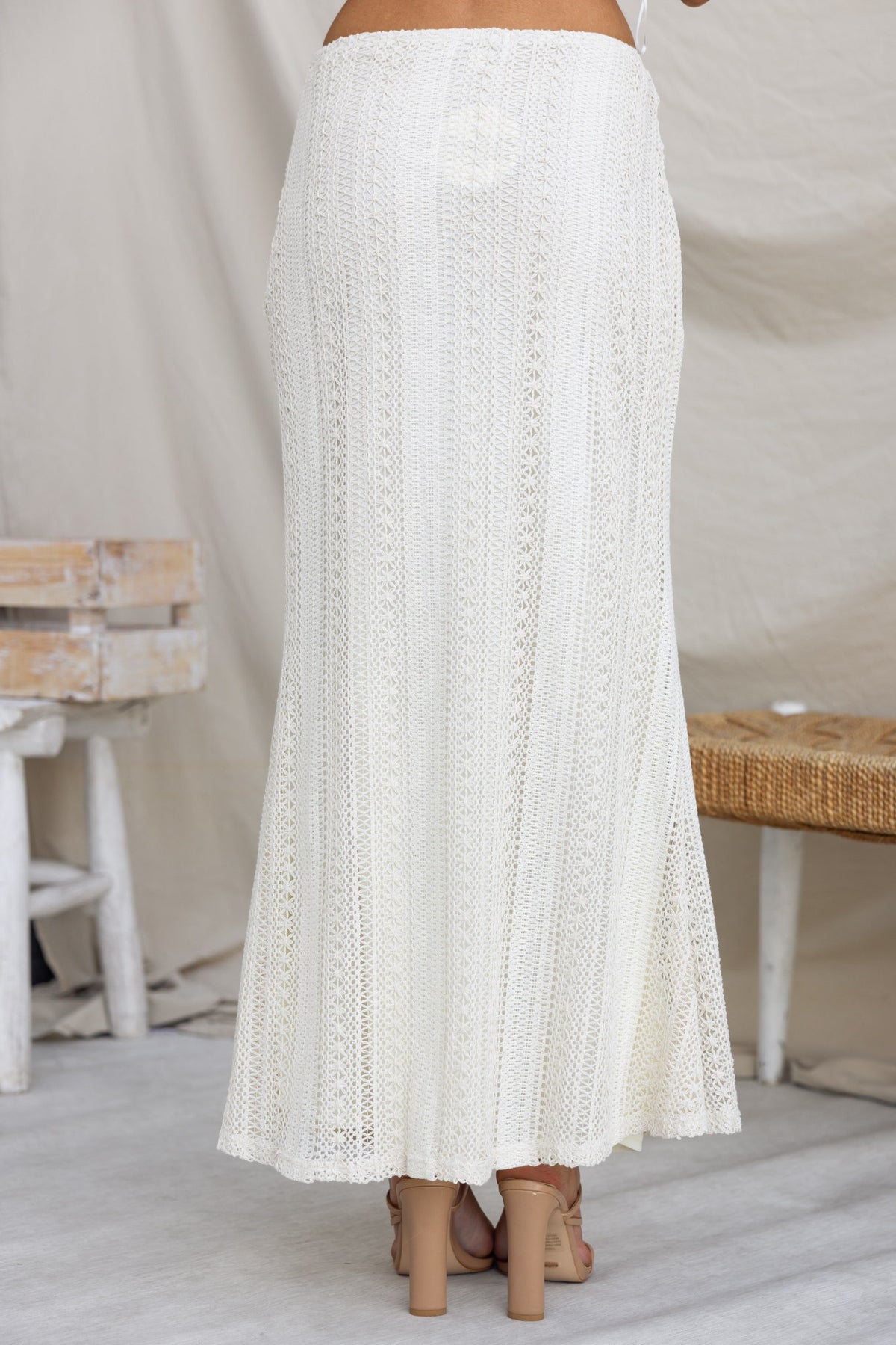 Odae white maxi skirt with crochet detailing and mid-high waist fit, showcasing a flowy design and tie detail at the waist.