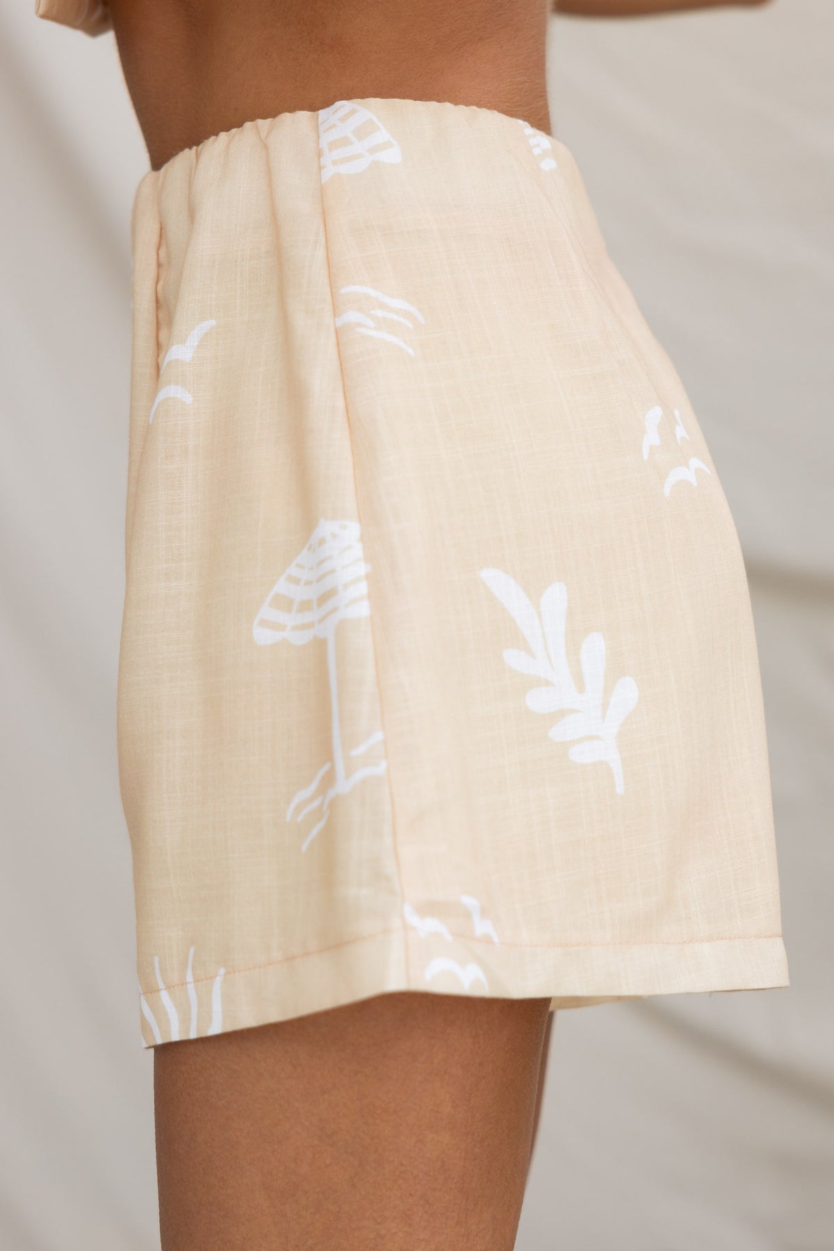 Canary shorts featuring a high-waisted fit, elastic waistband, and a tropical print on a light cotton fabric.