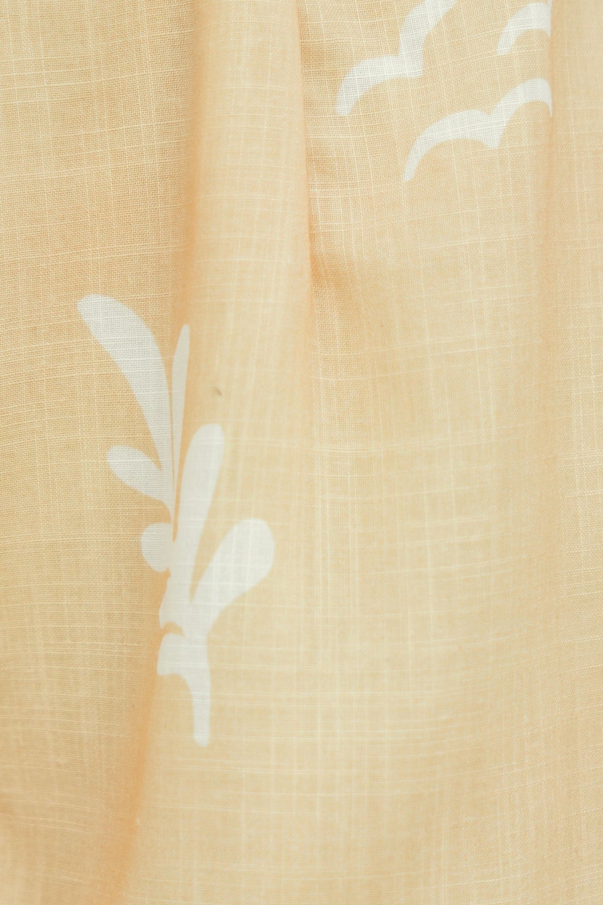Close-up of light canary fabric with white floral and cloud patterns, showcasing soft texture and design.