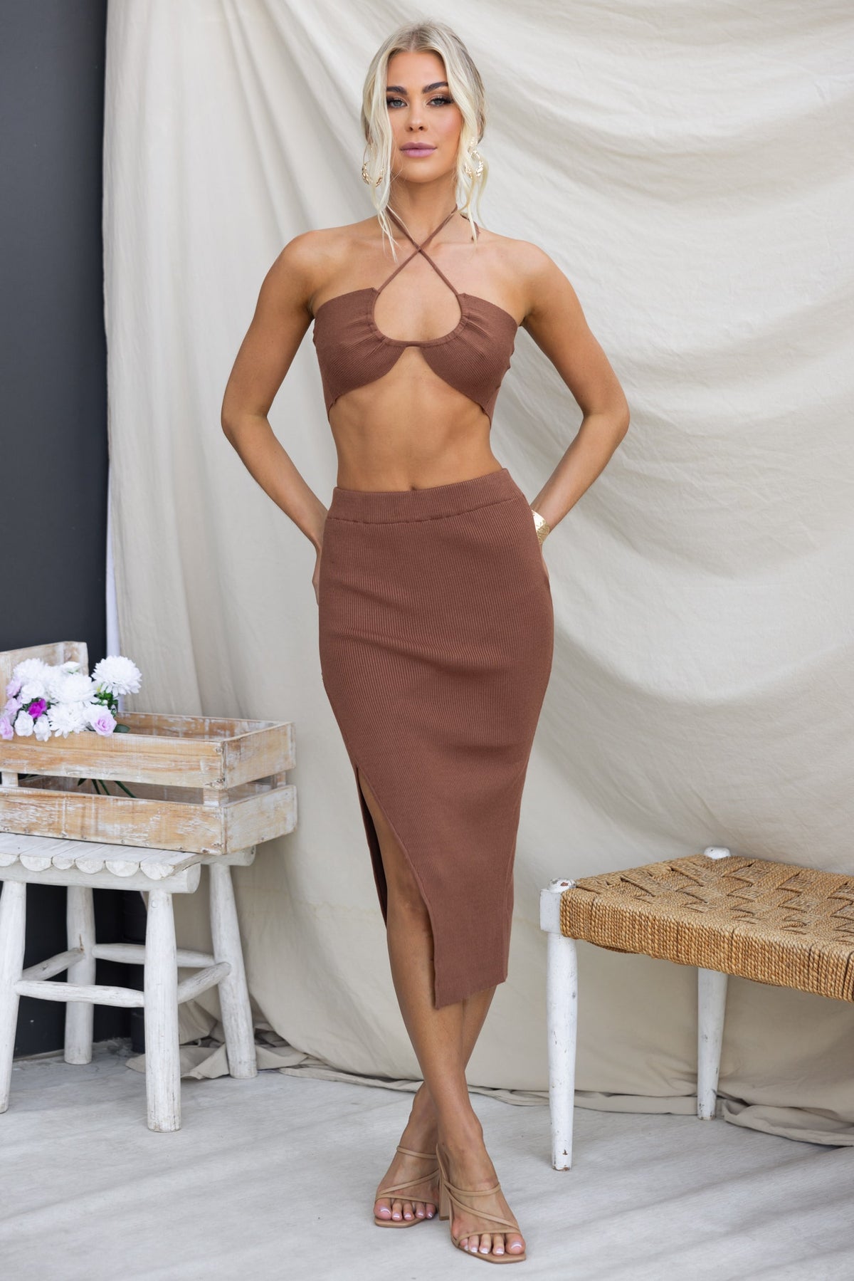Model wearing a brown Joie Midi Skirt with a matching cropped top, showcasing an asymmetric hem and stylish fit.