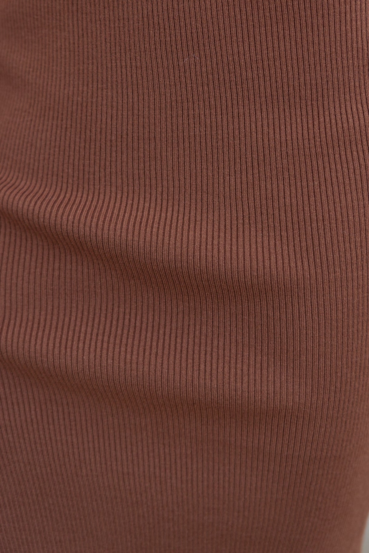 Close-up of the ribbed knit material of the Joie Midi Skirt in a rich brown hue, showcasing its texture and stretch.