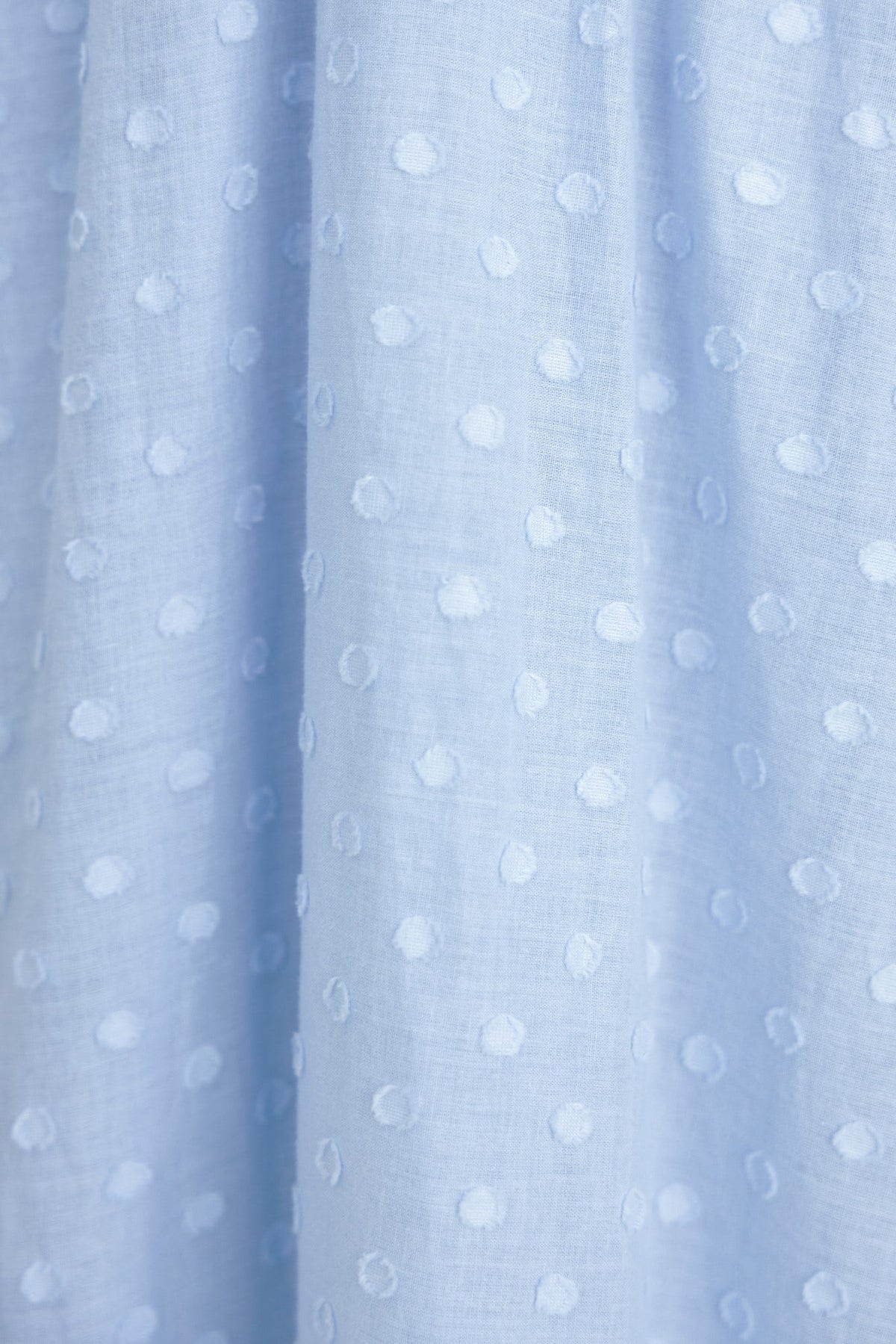 Light blue textured cotton fabric with dotted pattern, ideal for a stylish midi dress.