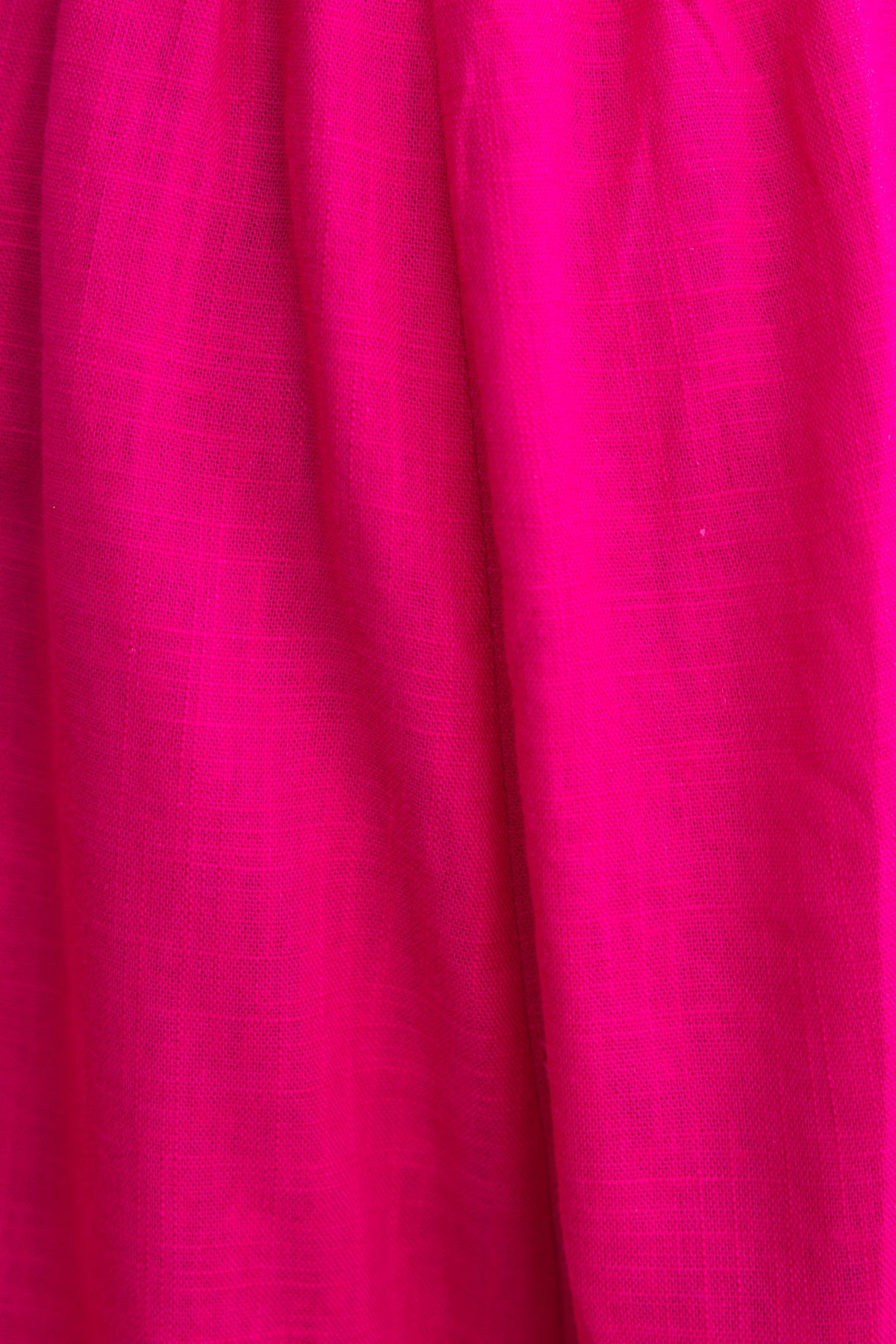 Close-up of vibrant pink linen fabric, ideal for Kippy Playsuit, showcasing its texture and color.