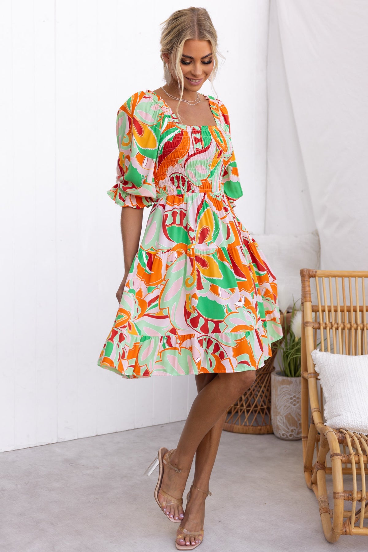 Tremmy Dress featuring an elastic bodice, vibrant floral print, and tie-back design, ideal for summer outings.