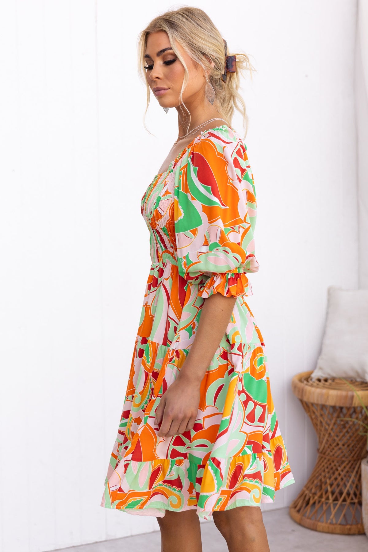 Model wearing the Tremmy Dress, featuring an elastic bodice and vibrant floral prints, ideal for casual summer outings.