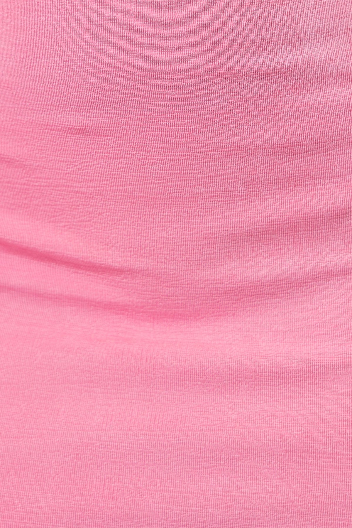 Close-up of Jasalina Dress showcasing soft pink draping material with a smooth texture.