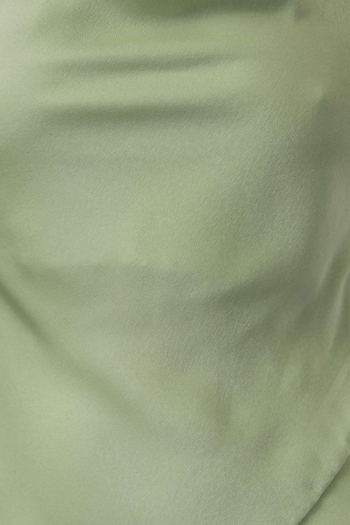 Close-up of soft, satin fabric in light green, highlighting its smooth texture for the Ankana Dress.