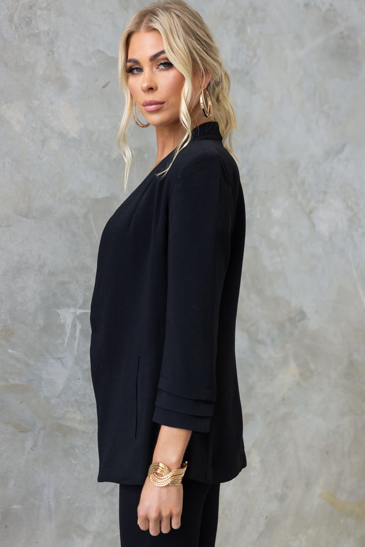 Lupton Blazer in black, featuring pleated sleeves and front pockets, styled on model for a chic look.