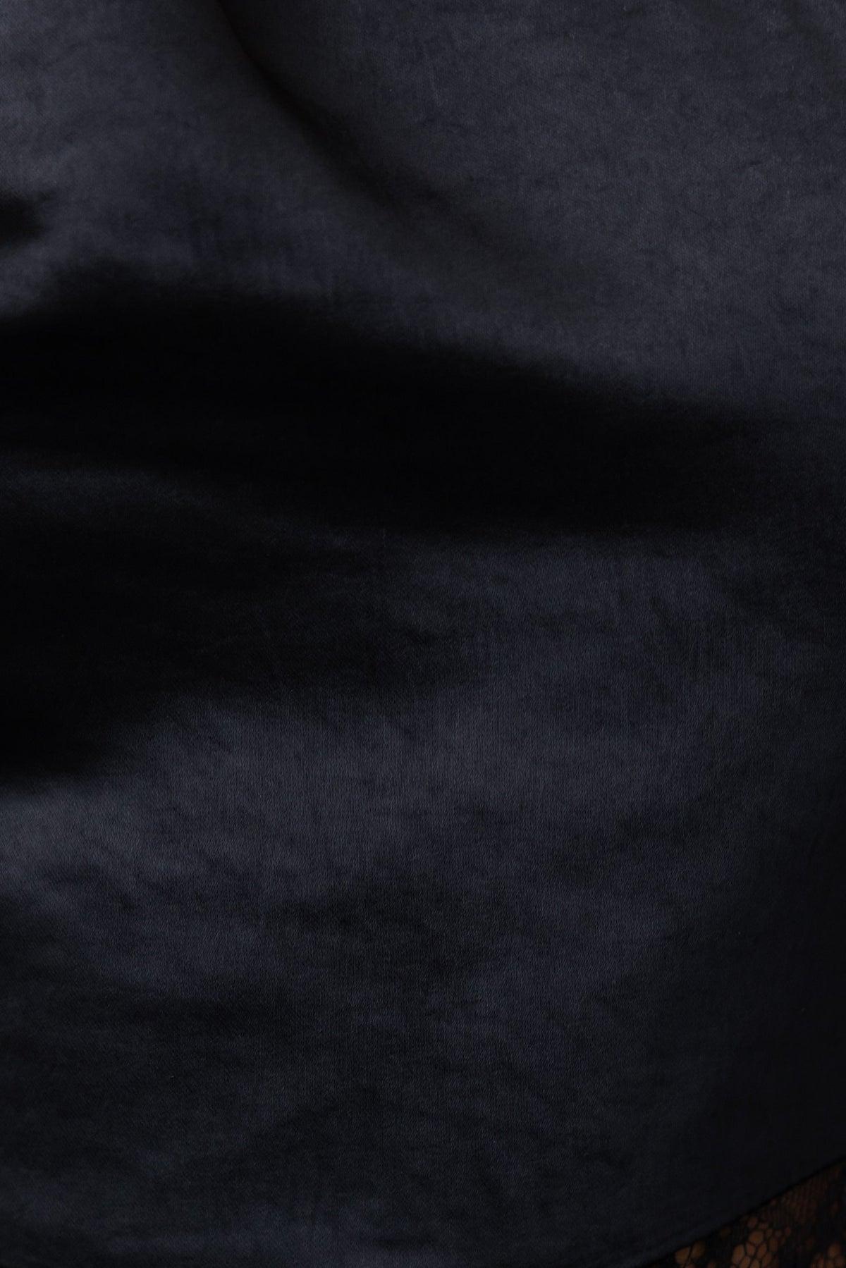 Close-up of the luxurious satin fabric of the black Bombshell Maxi Dress, showcasing its smooth texture and elegant finish.