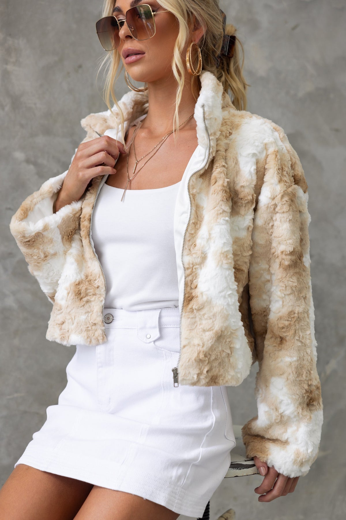 Florida Jacket featuring a high neckline and zip-up front, displayed on a model with sunglasses and a skirt.