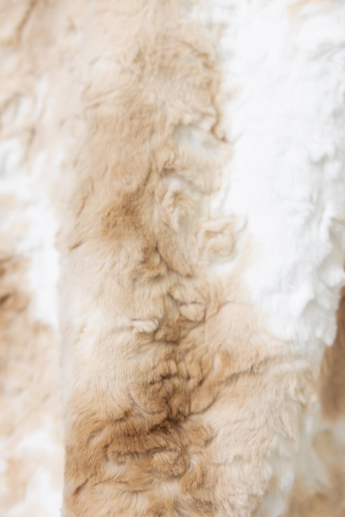 Close-up of soft fluffy material in beige and white, showcasing the texture used in the Florida Jacket.