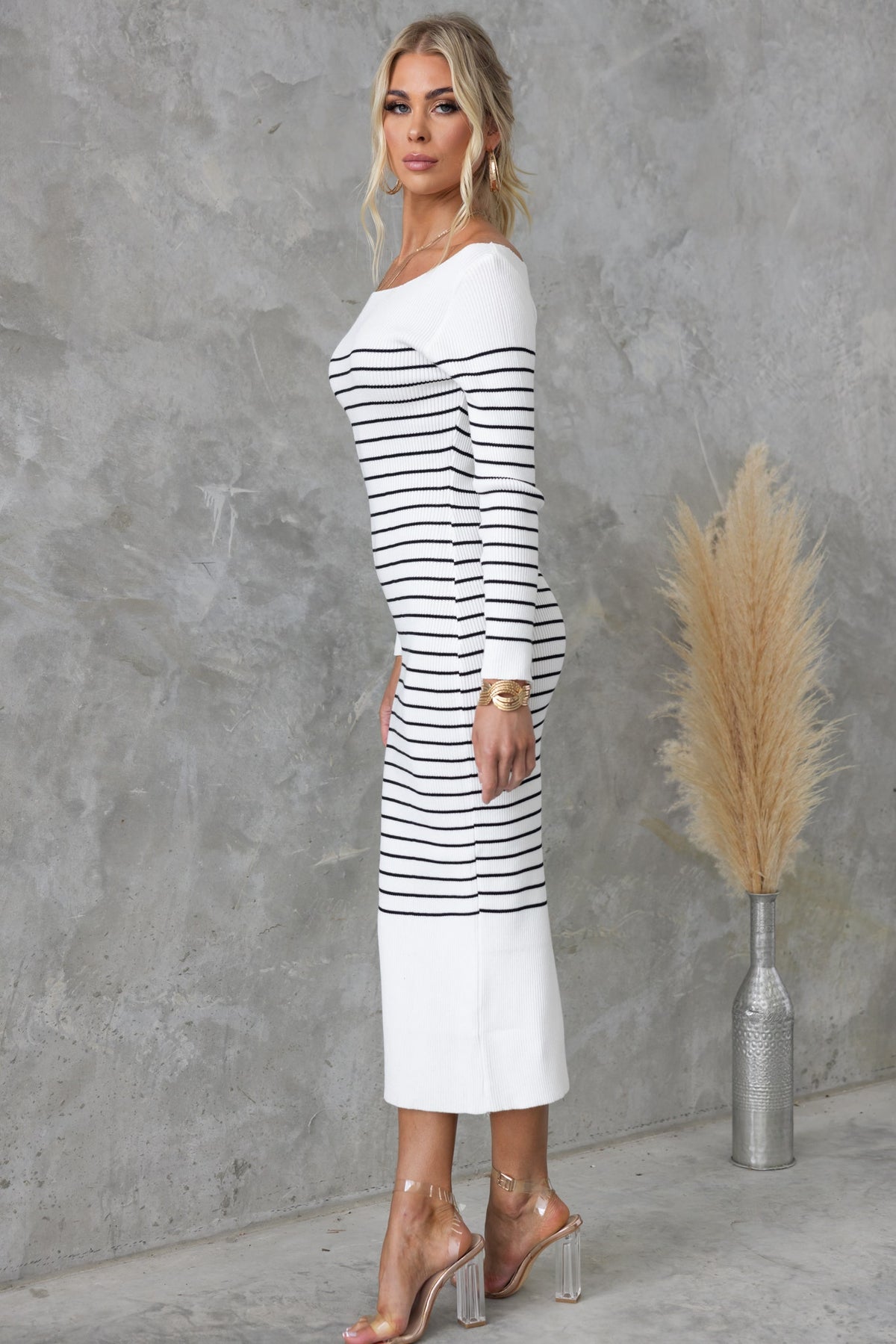 Model wearing Gamani Midi Dress with boat neckline and striped design, showcasing a stylish fit against a neutral background.