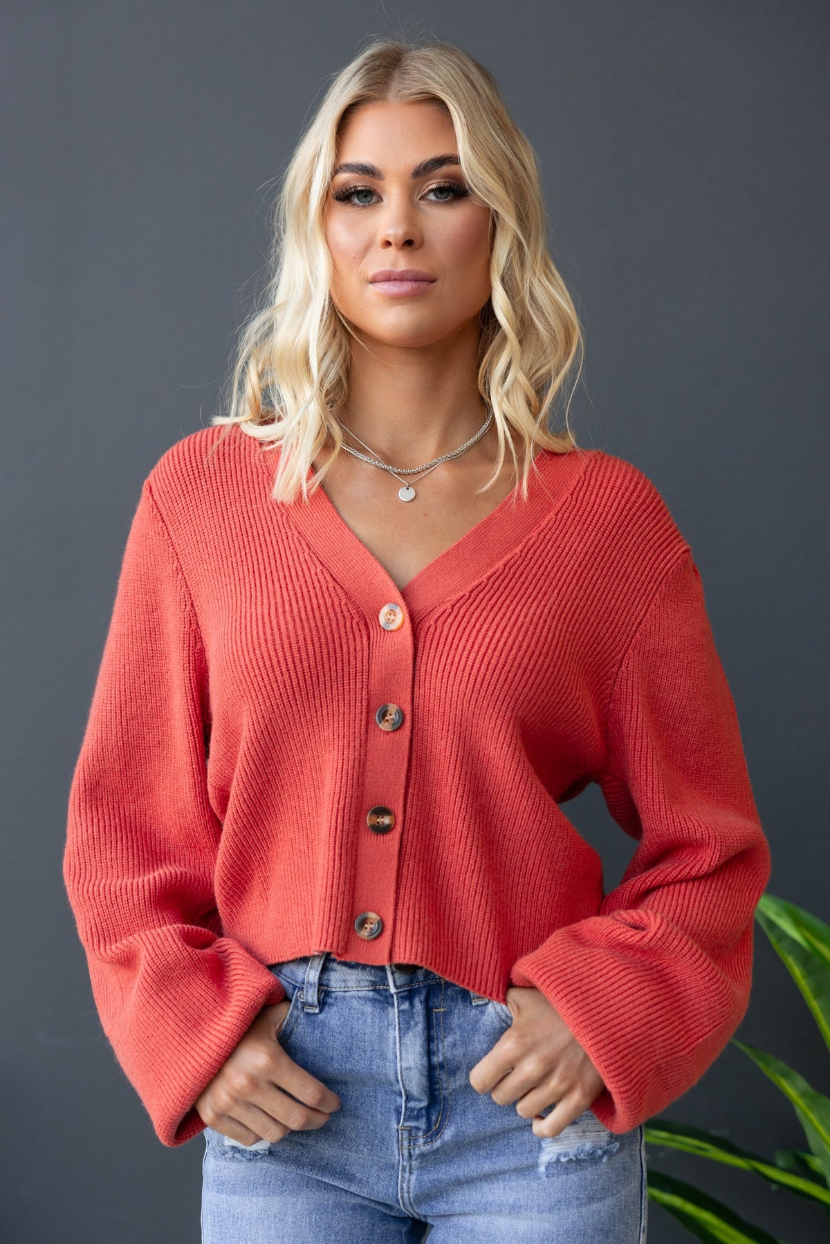 Modalla Cardigan in coral featuring V-neckline and button-up front with ribbed knit texture.