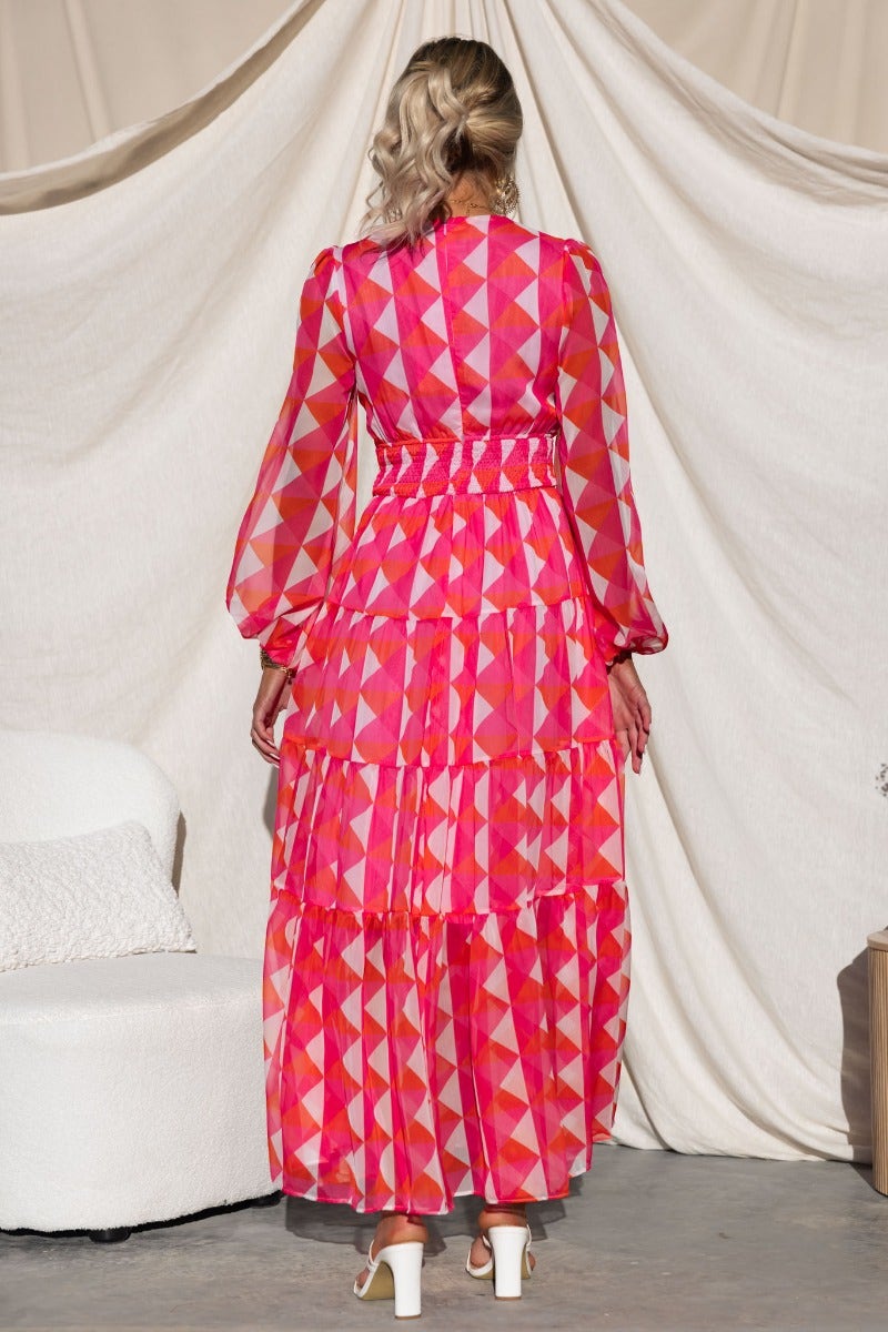 Back view of Cotta Maxi Dress featuring multicolored geometric patterns, elastic cuffs, and tiered ruffles.