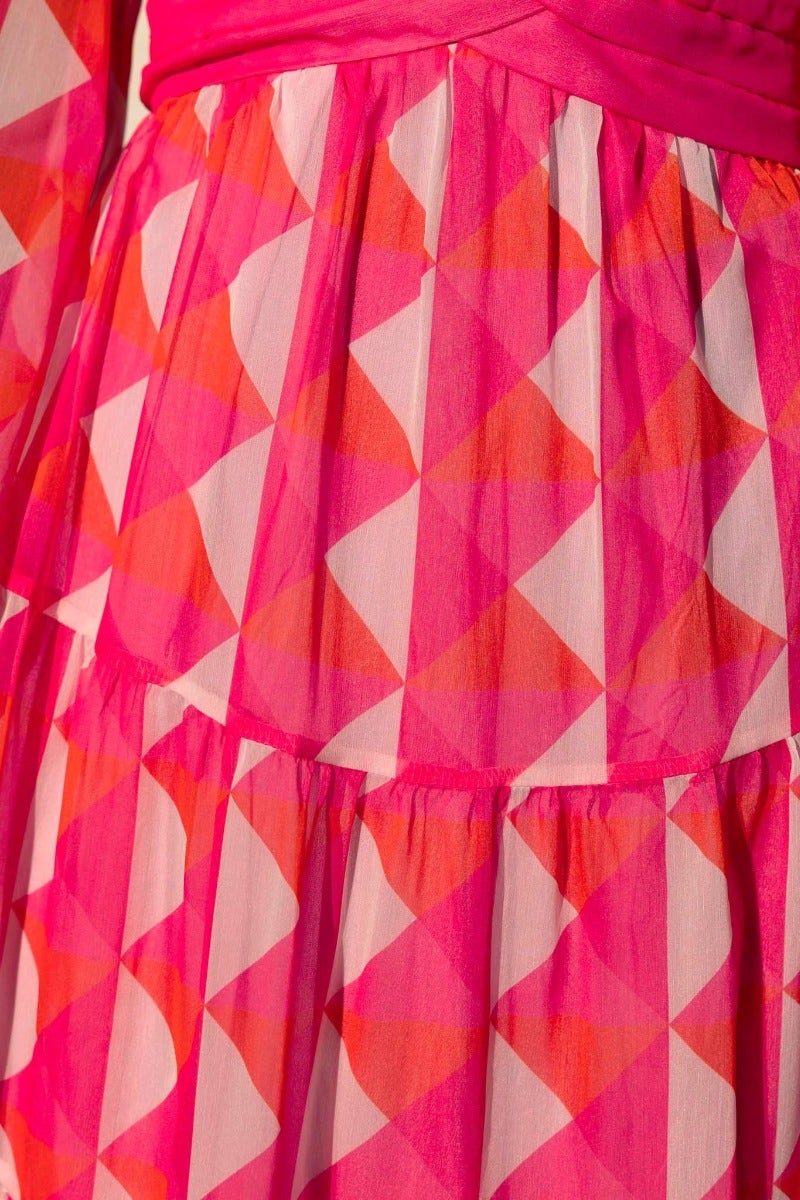 Close-up of the vibrant multi-colour patterned skirt of the Cotta Maxi Dress, featuring pink and orange geometric shapes.