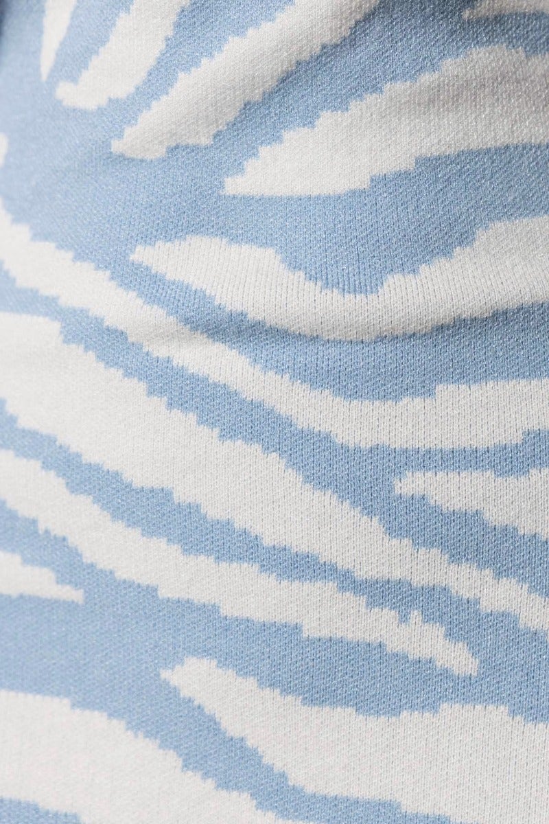 Close-up of blue knit fabric with white zebra stripes, showcasing texture and pattern for the Harleen Midi Dress.