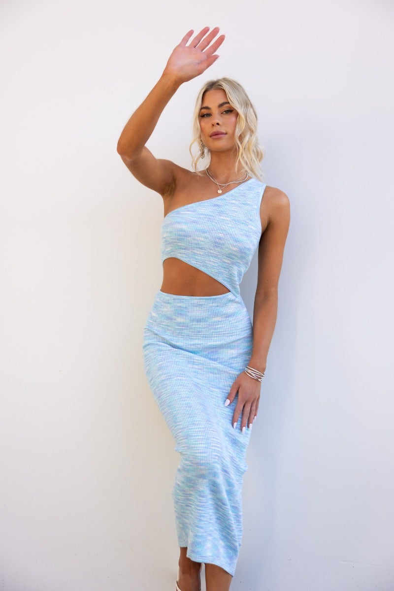 Model wearing a Tamias midi dress featuring a ribbed knit design, one-shoulder neckline, and front cut-out.