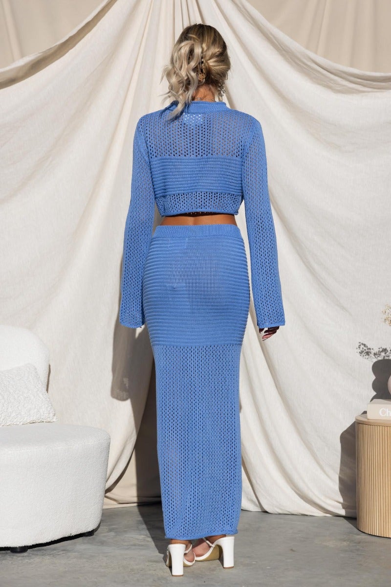 Woman wearing blue crochet Kholo set with high neckline crop top and fitted skirt, showcasing a chic back view.