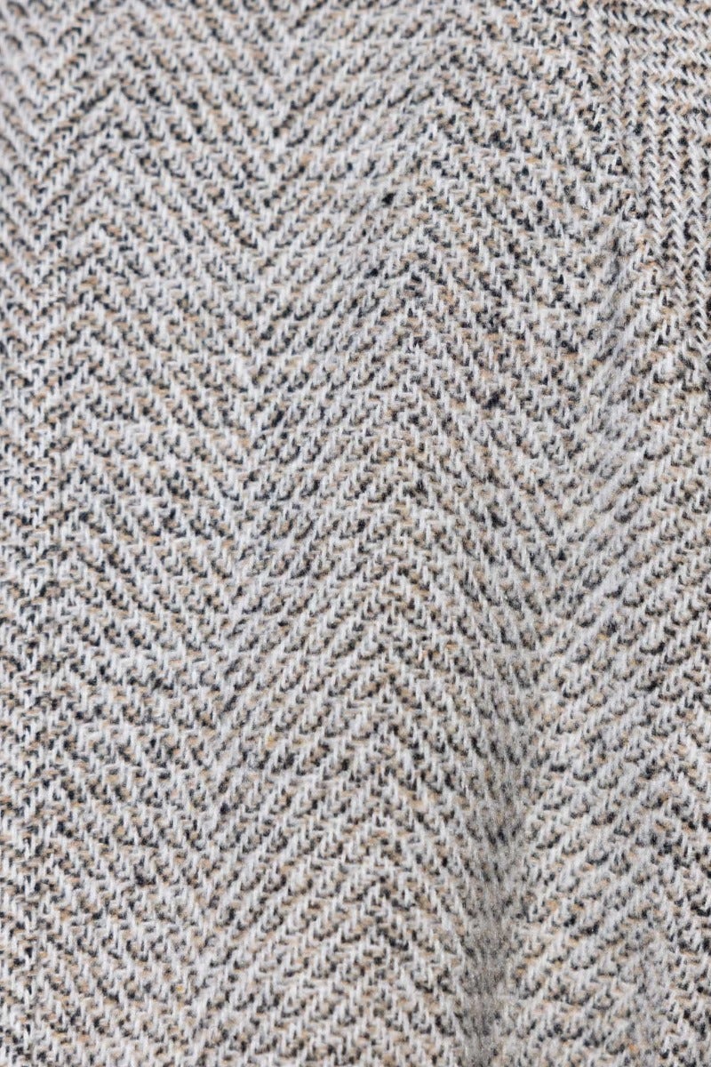 Tweed fabric close-up showcasing herringbone pattern for stylish outerwear.