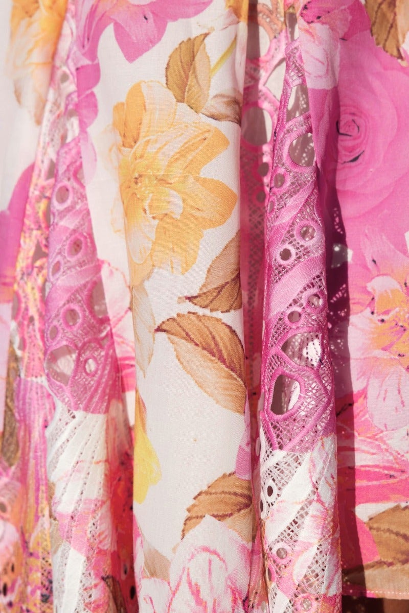 Close-up of Chasing Dreams Dress featuring floral print and lace detailing in pink and yellow tones.
