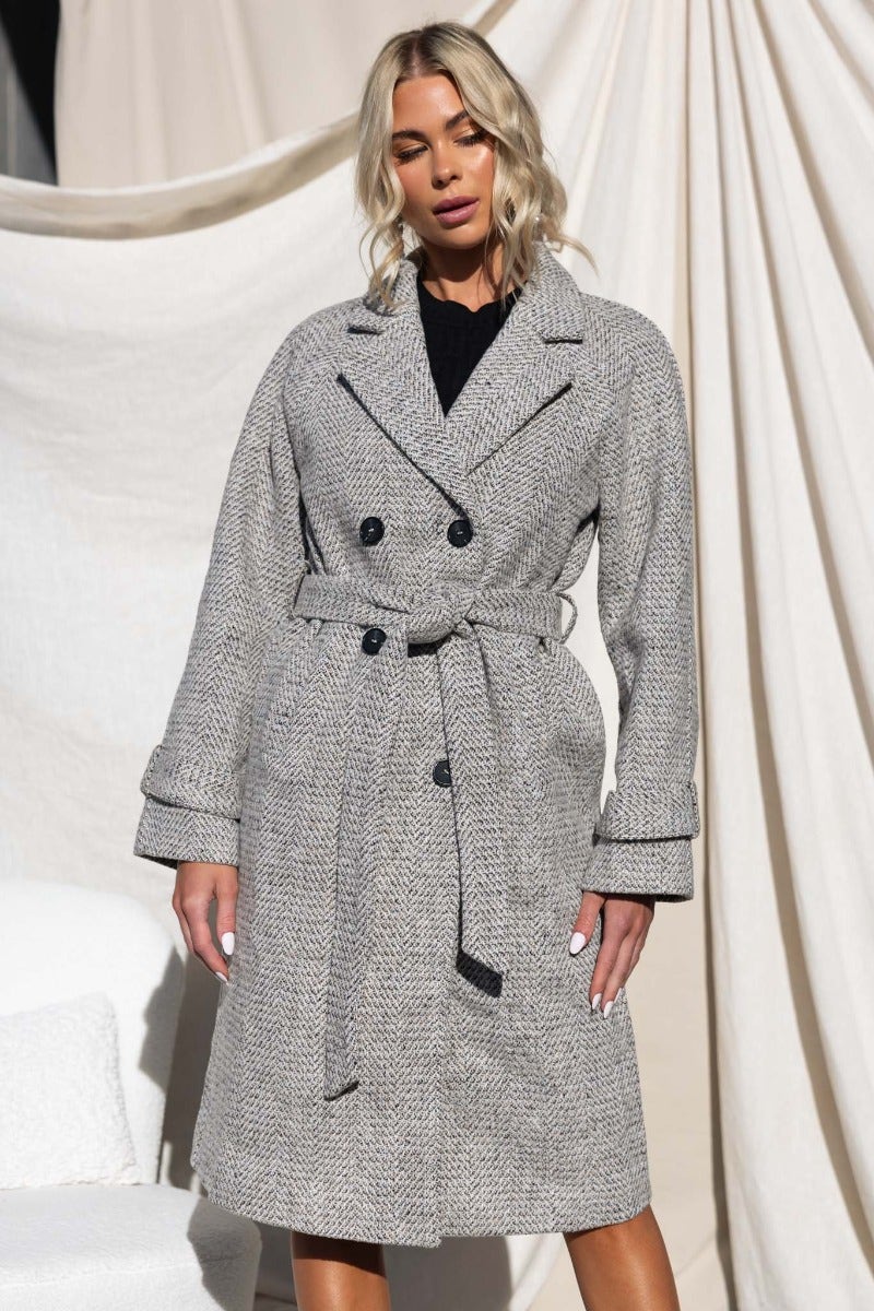 Longline Atthow Coat in tweed look with collar, belt, pockets, and button-up front, modeled by a woman.