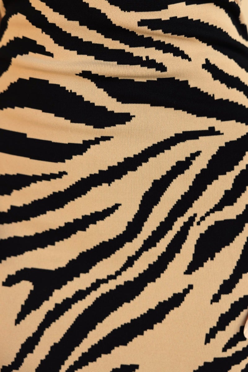 Close-up of beige fabric with black zebra stripes, showcasing unique pattern and texture.