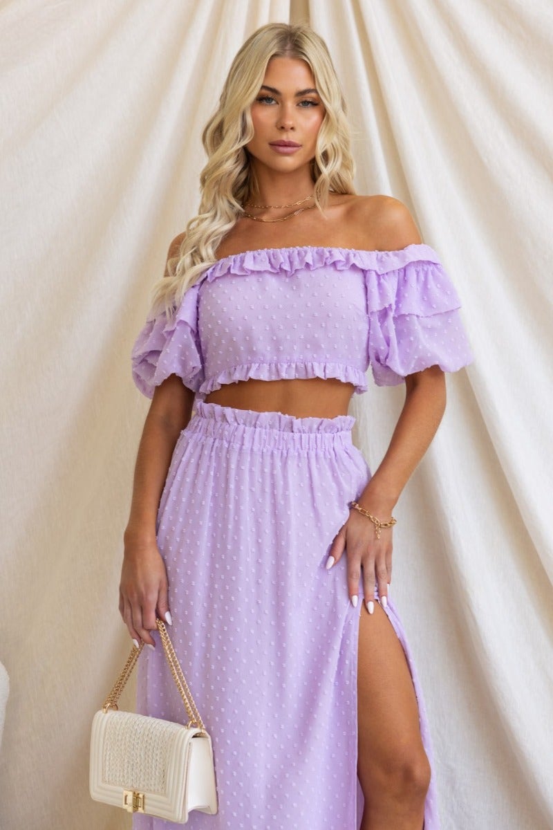 Rosalia Top in textured lavender off-shoulder style with ruffles, paired with a matching skirt for a chic look.