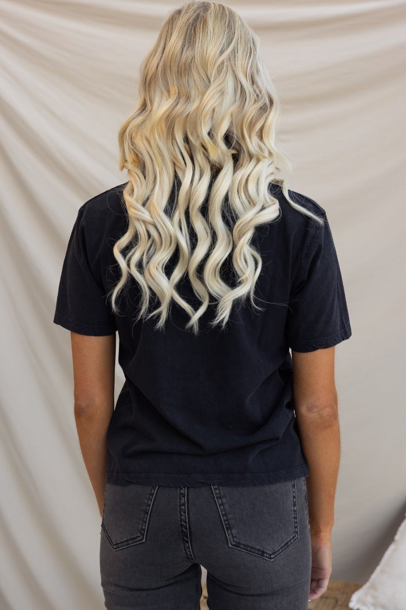 Back view of a woman wearing a washed black Jerome Tee from Silent Theory Clothing Co with relaxed fit.