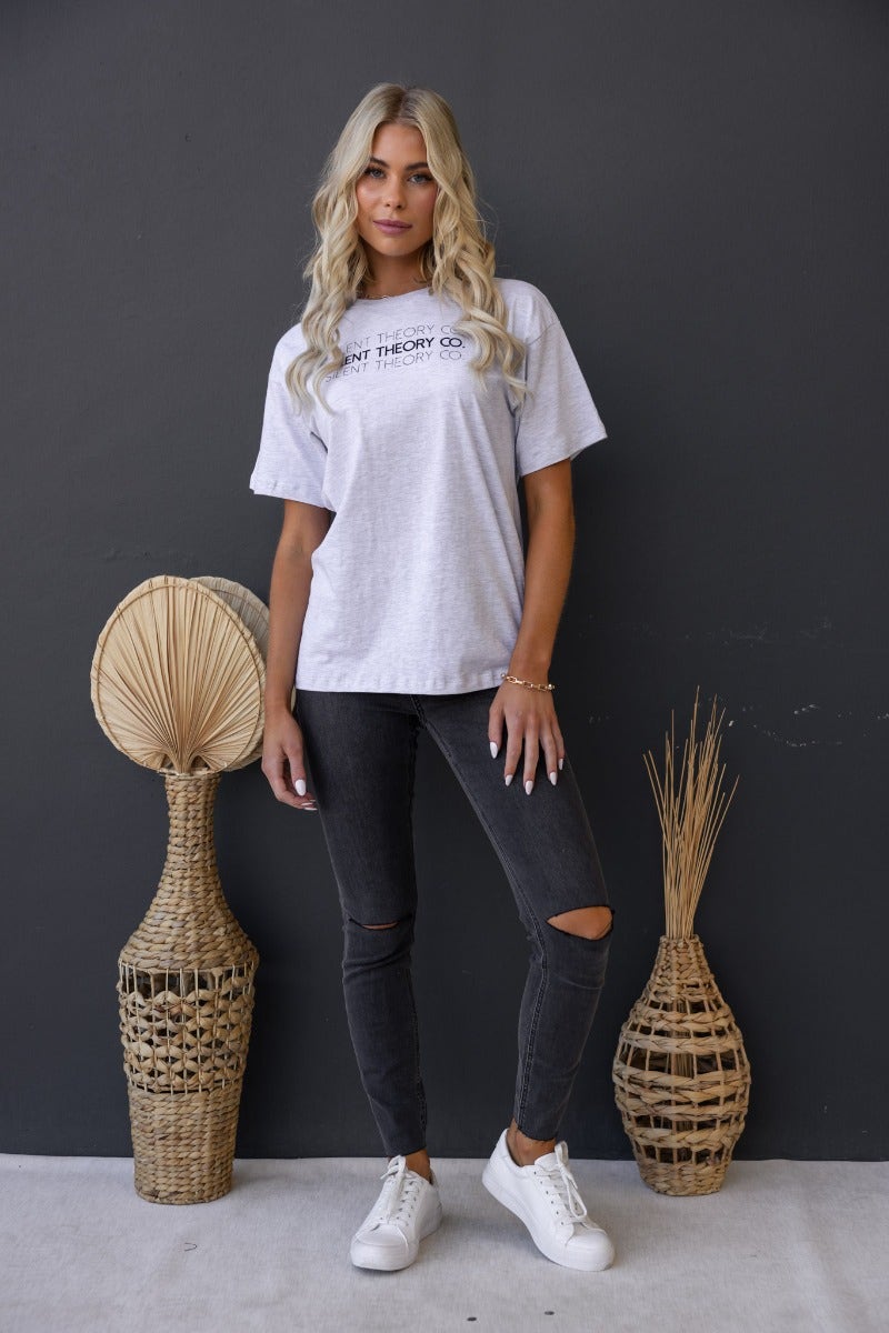 Model wearing the Ronan Tee from Silent Theory Co, featuring a round neckline and relaxed fit, paired with black skinny jeans.