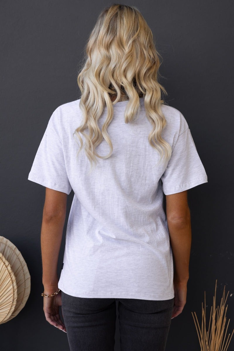 Back view of a woman wearing a lightweight gray Ronan Tee with round neckline and relaxed fit.