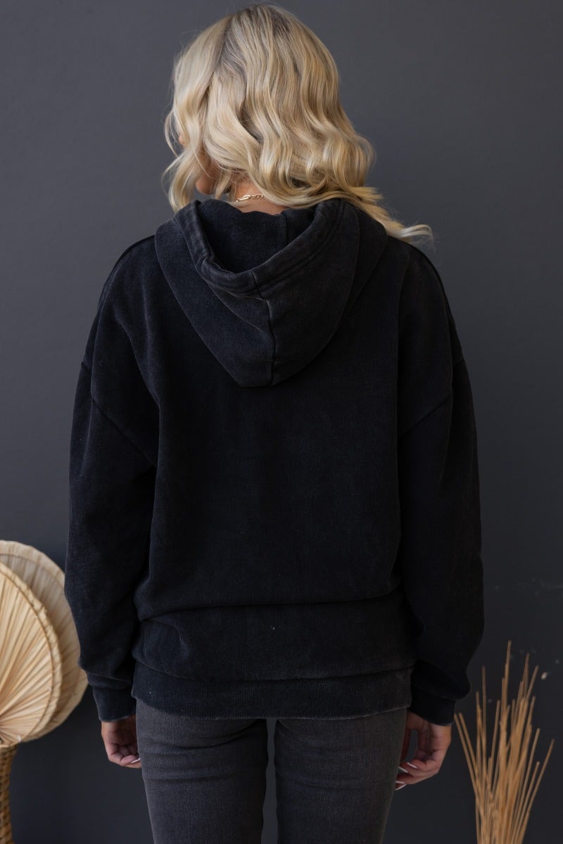 Back view of the Ivar Jumper in washed black, featuring a hood with drawstring and ribbed cuffs.