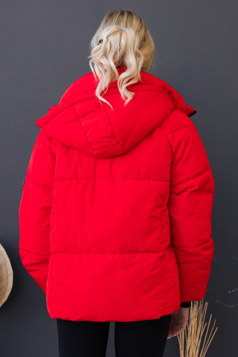 Back view of Delila Puffer Jacket in red with removable hood and high neckline, designed for active comfort.